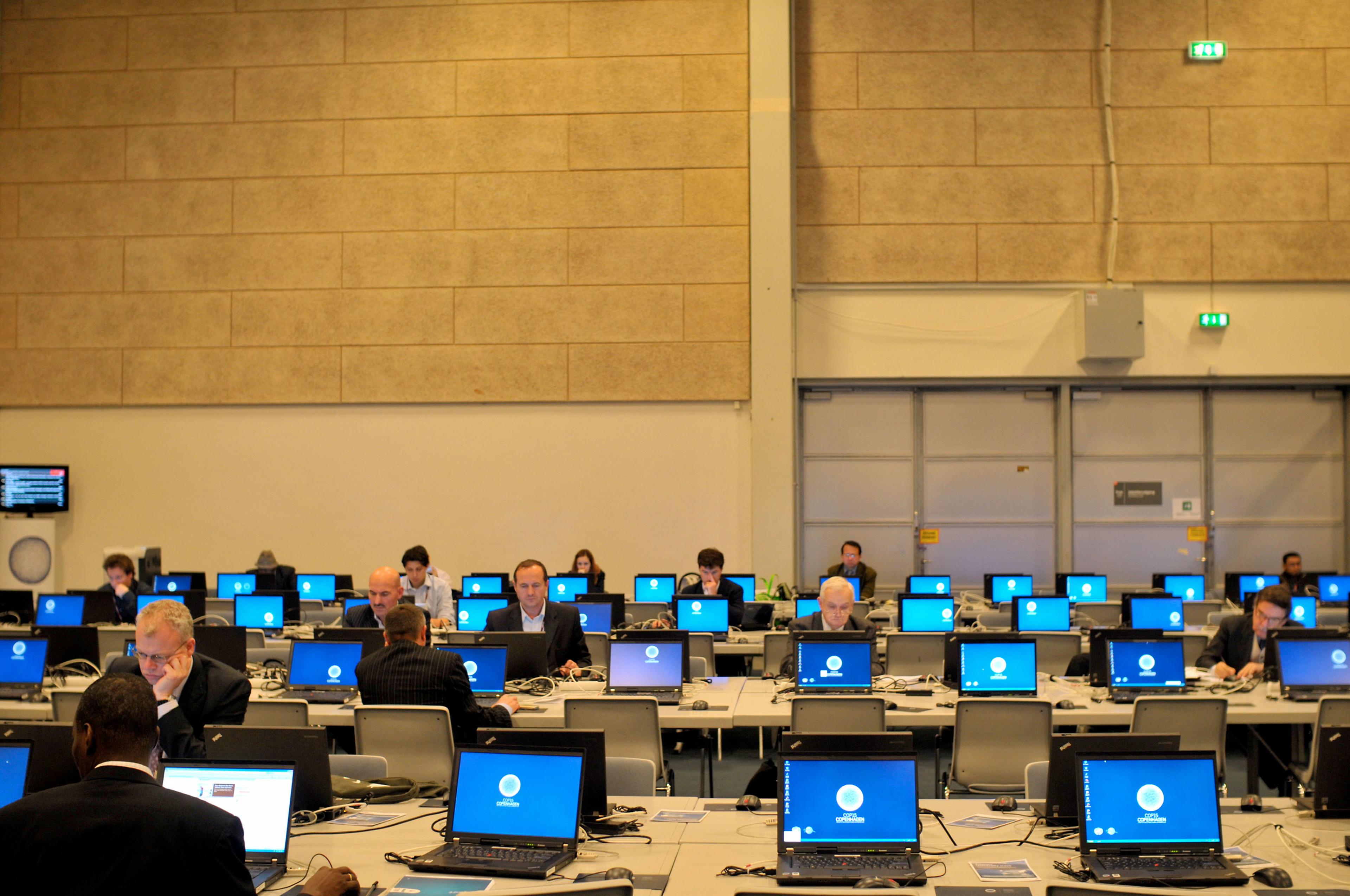 mensen werken achter een rij laptops