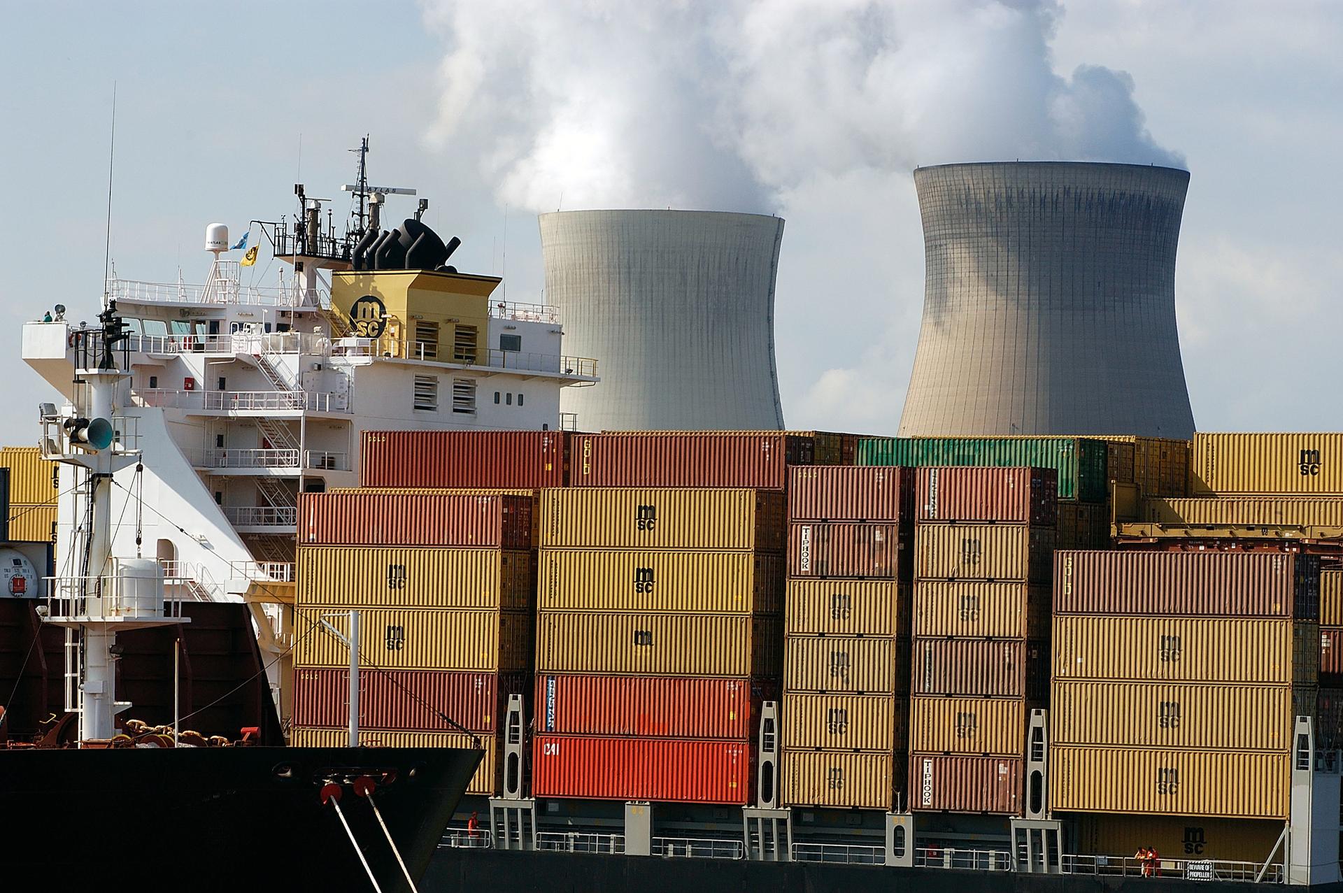 Containers in de haven, kerncentrale op de achtergrond, op de Noordzee
