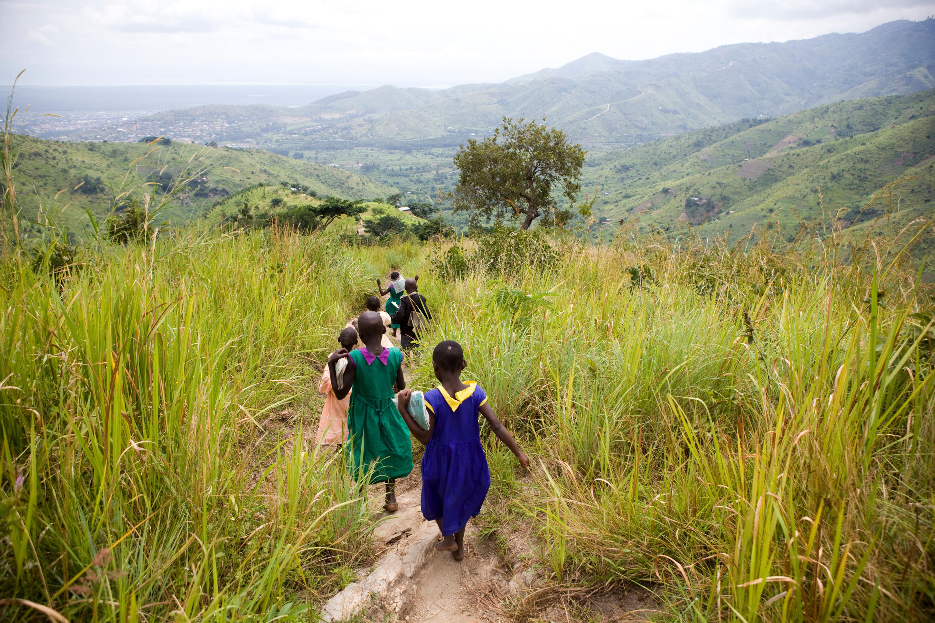 Kinderen wandelen door het hoge gras in Uganda