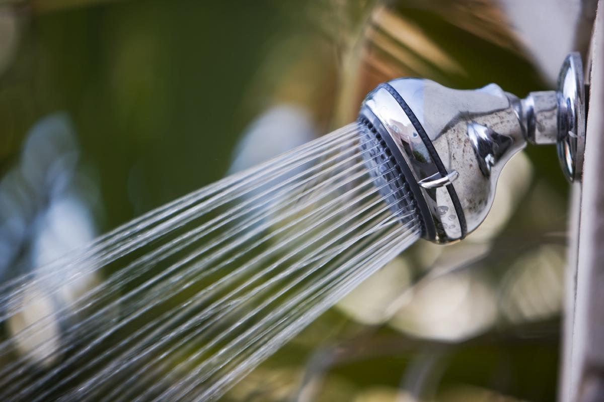 Water stroomt uit een douchekraan in een badkamer