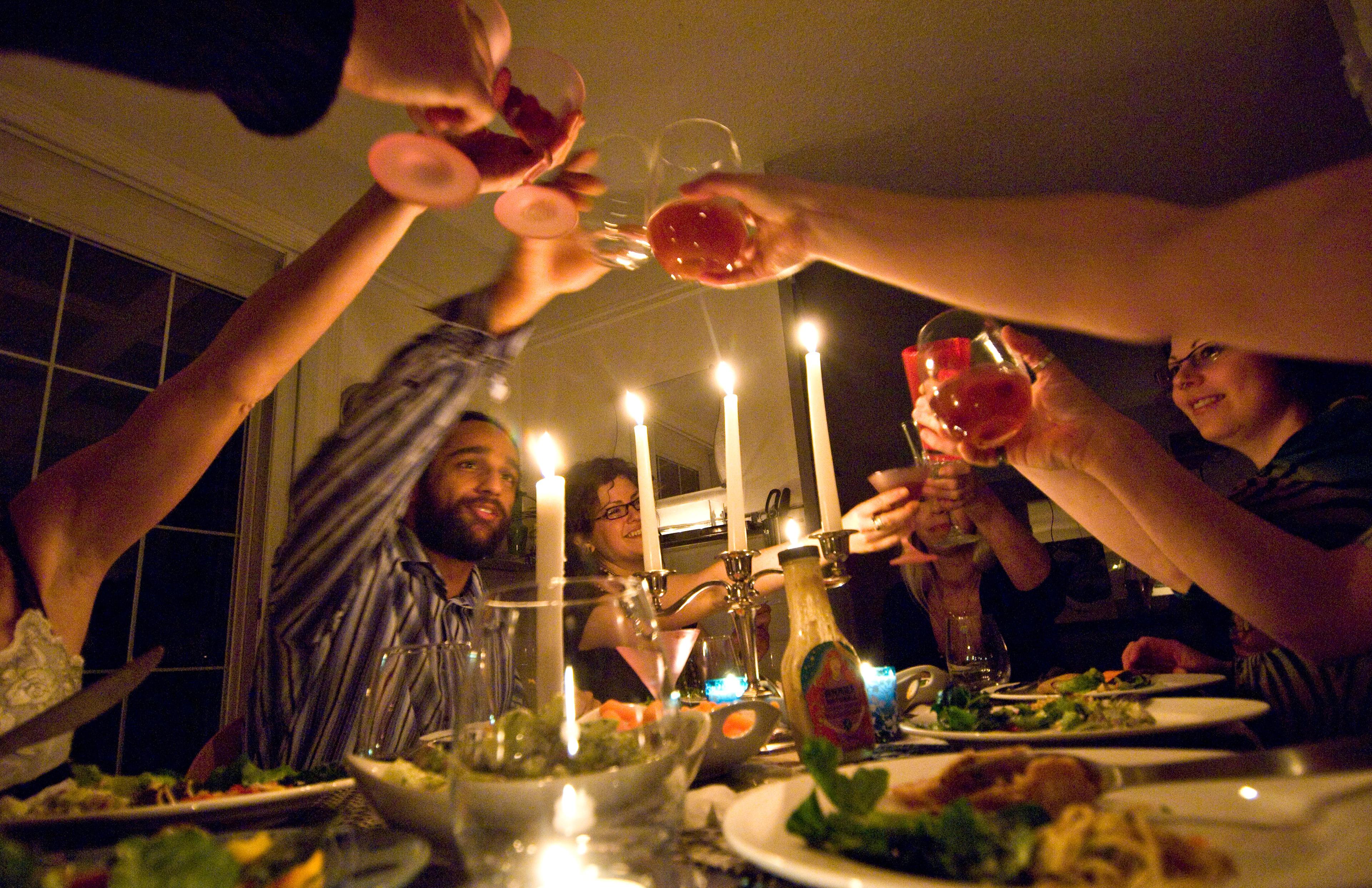 Mensen proosten tijdens een diner met kaarslicht