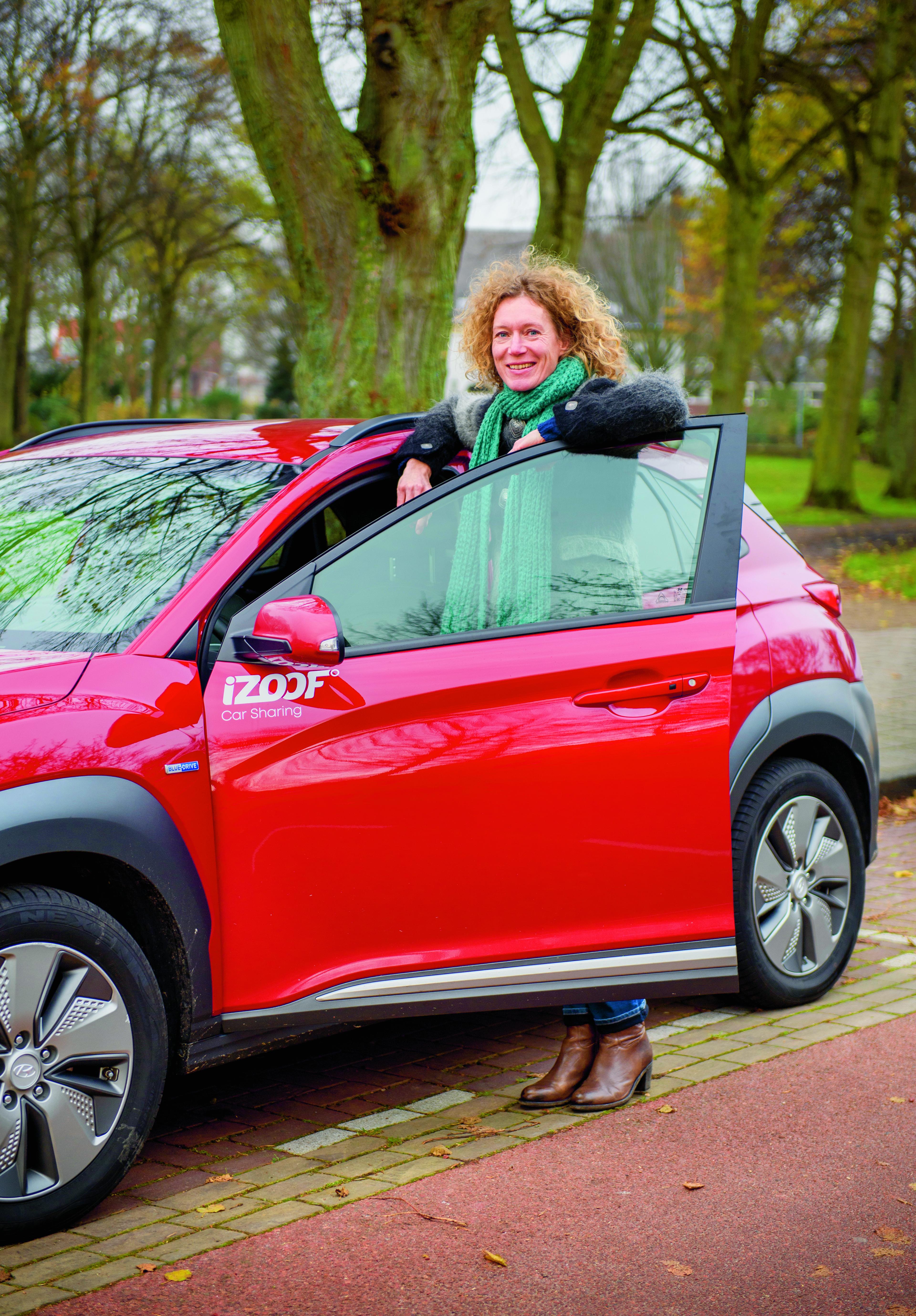 Anna staat in deuropening auto