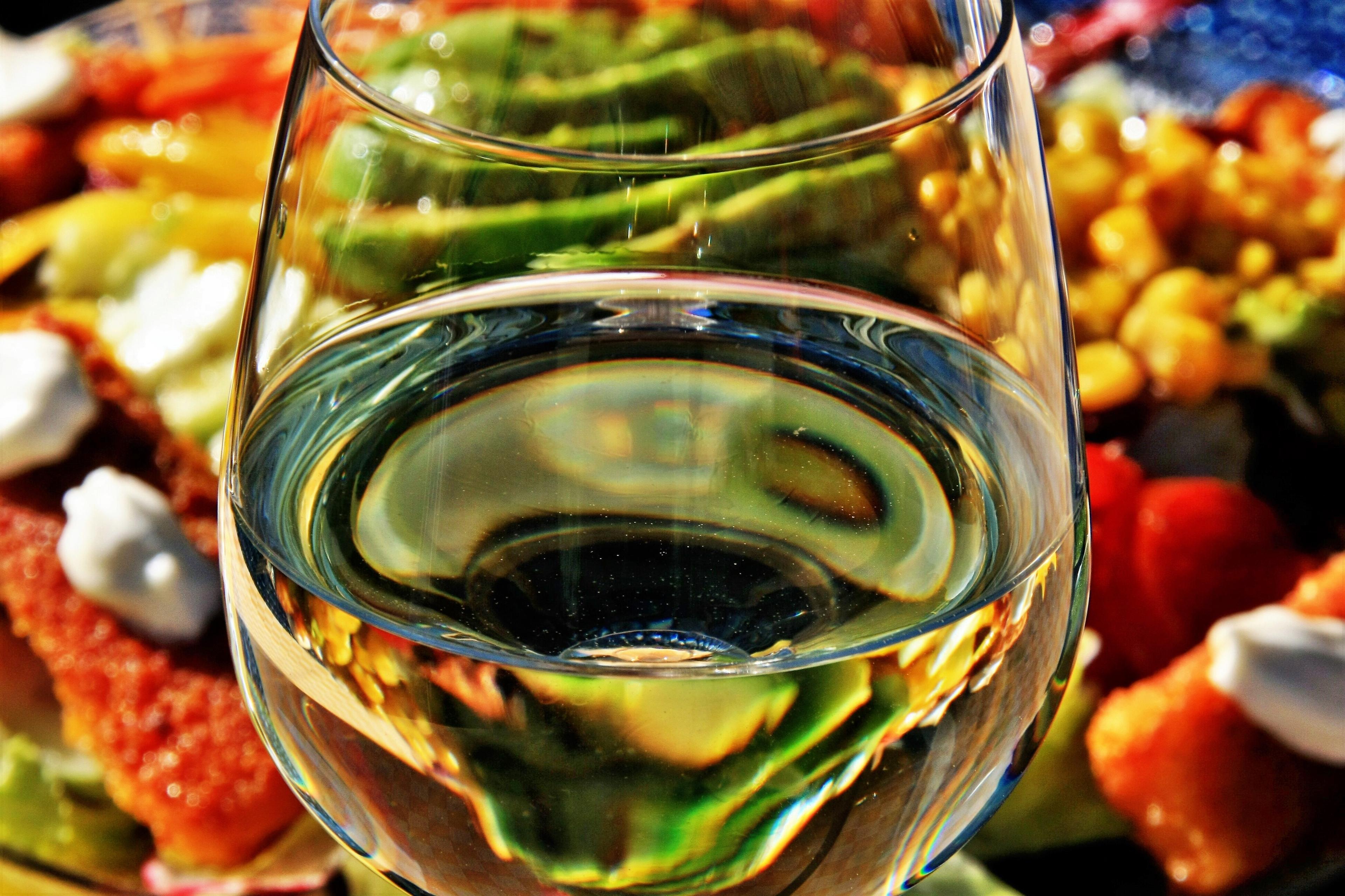 Glas met witte wijn, hapjes op de achtergrond