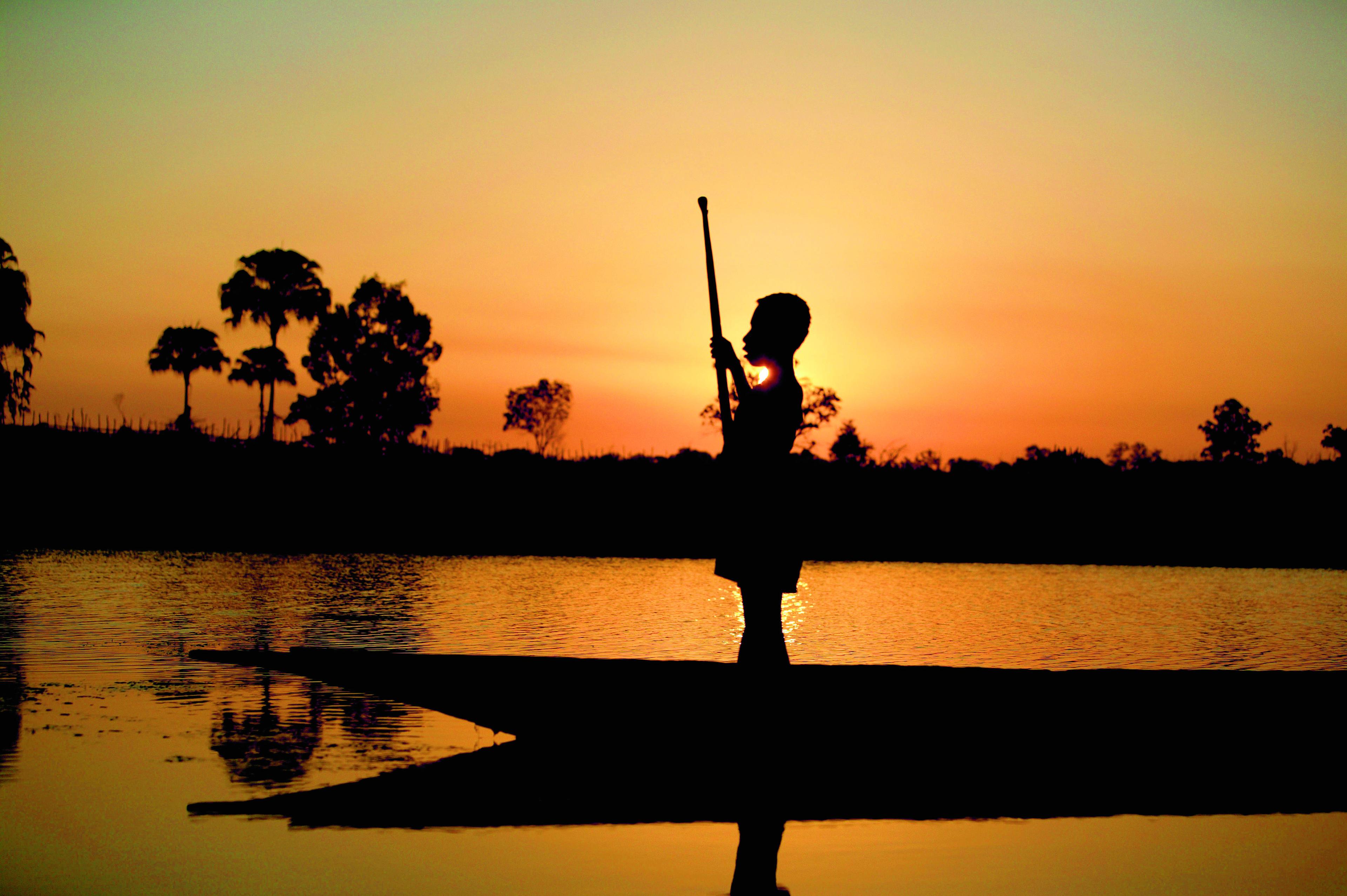 Jongen op een boot, zonsondergang