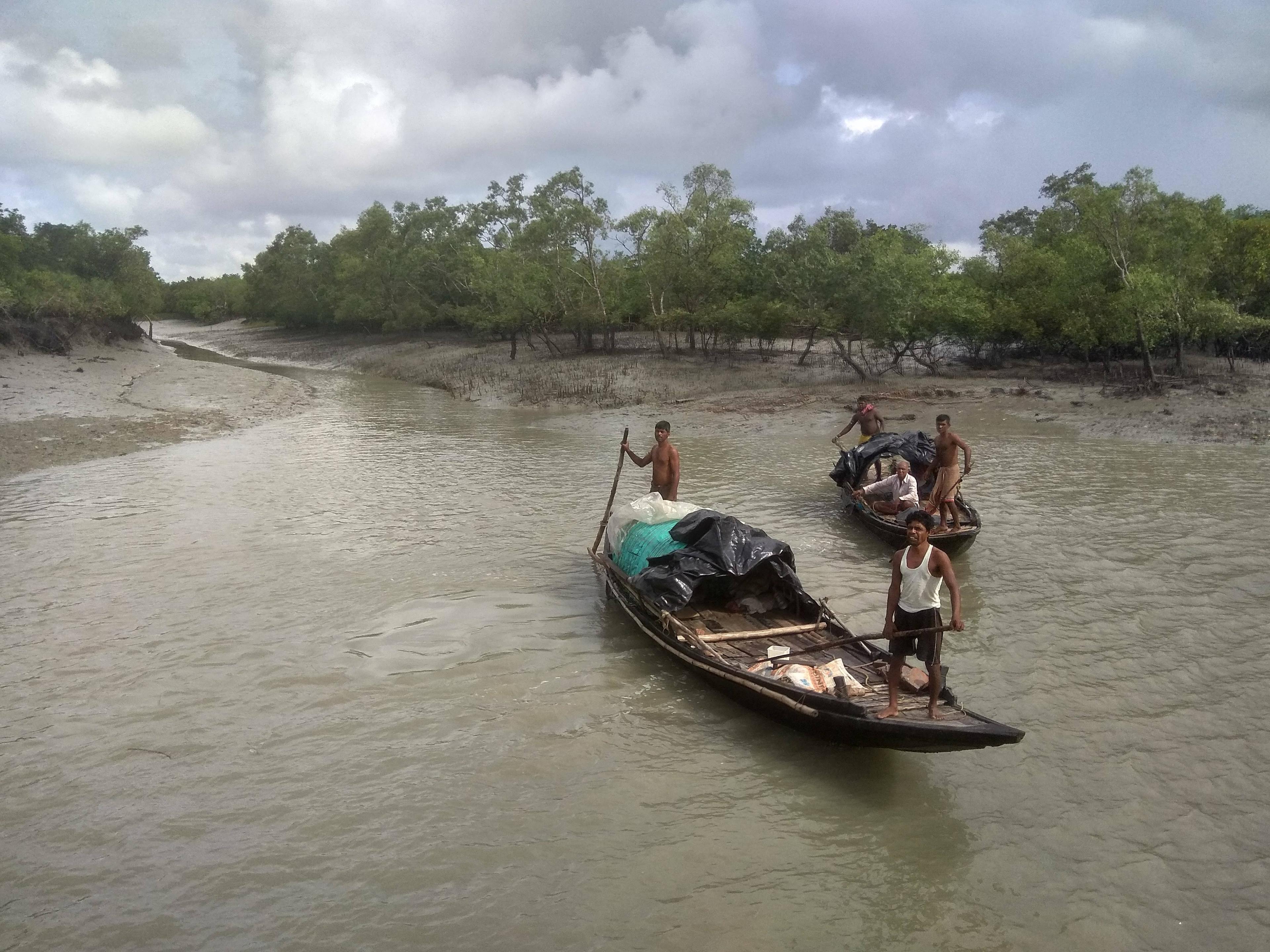 Lokale bewoners op een bootje in het water in Sundarbans