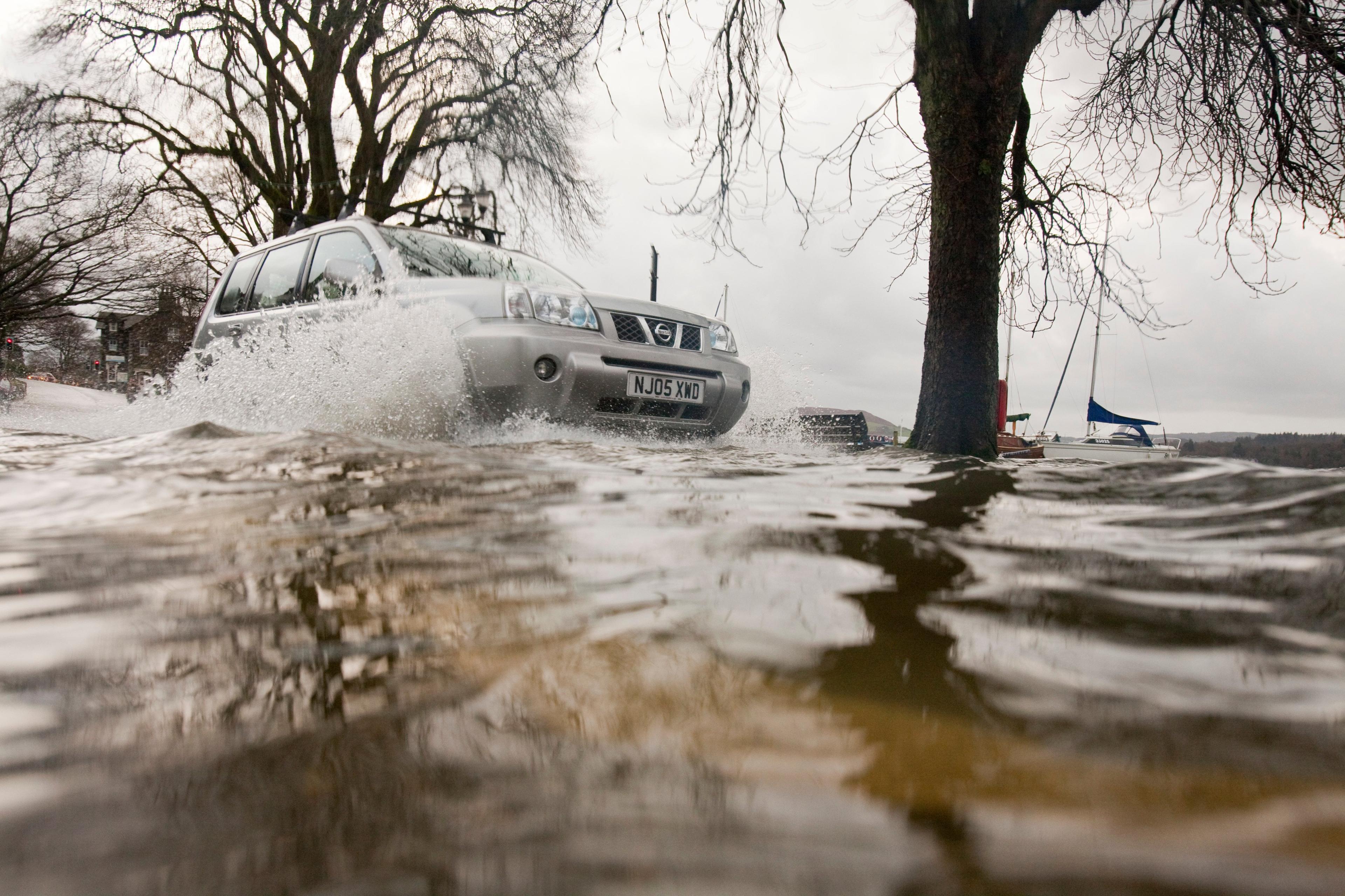 Auto rijdt door vloedwater
