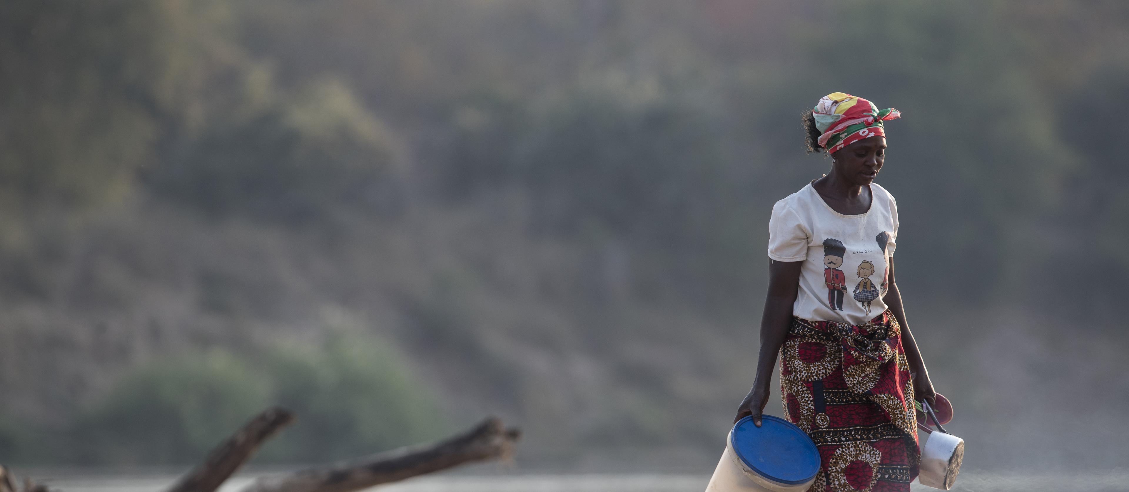 Een vrouw loopt langs de Luangwa Rivier, Zambia