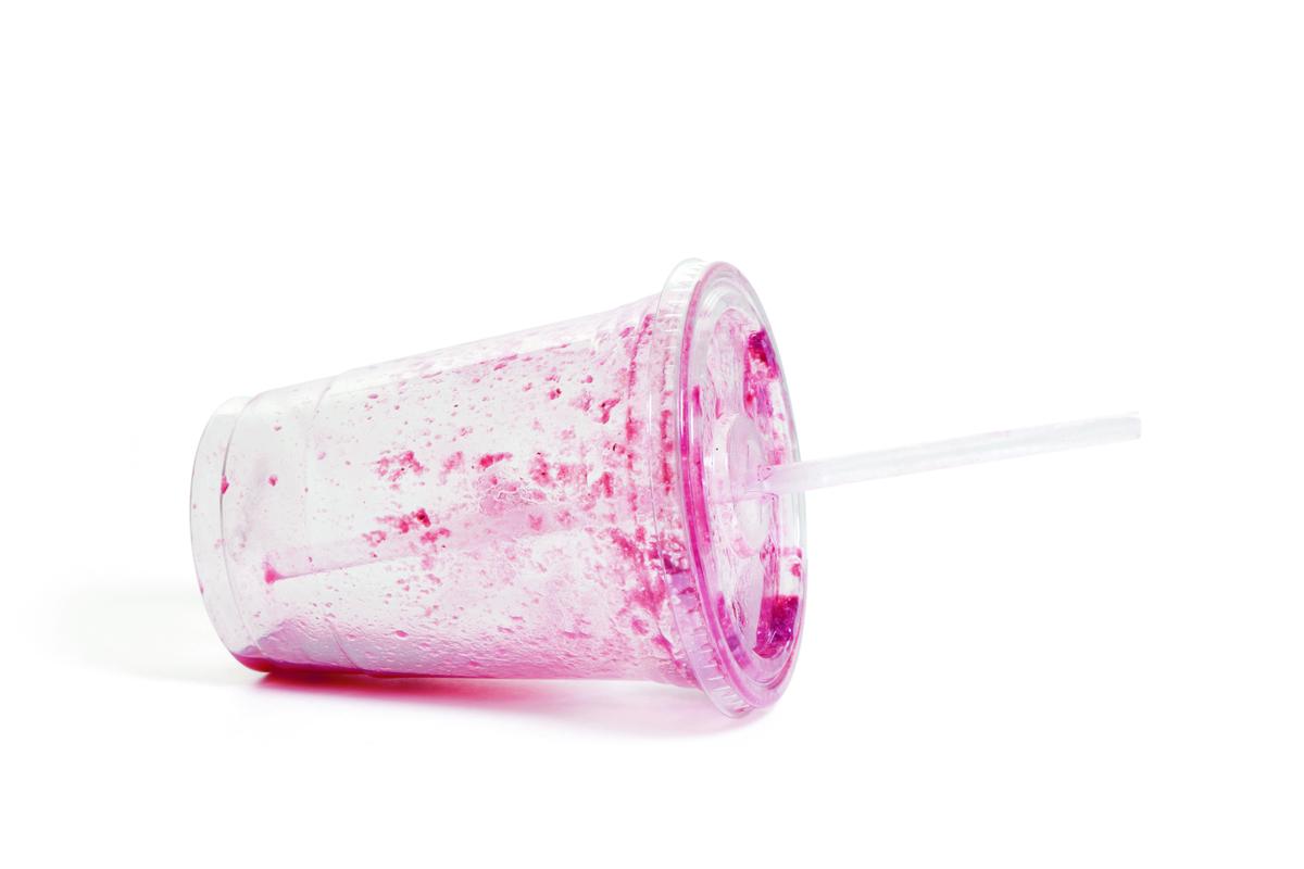 doorzichtige plastic beter met restje rode sap erin