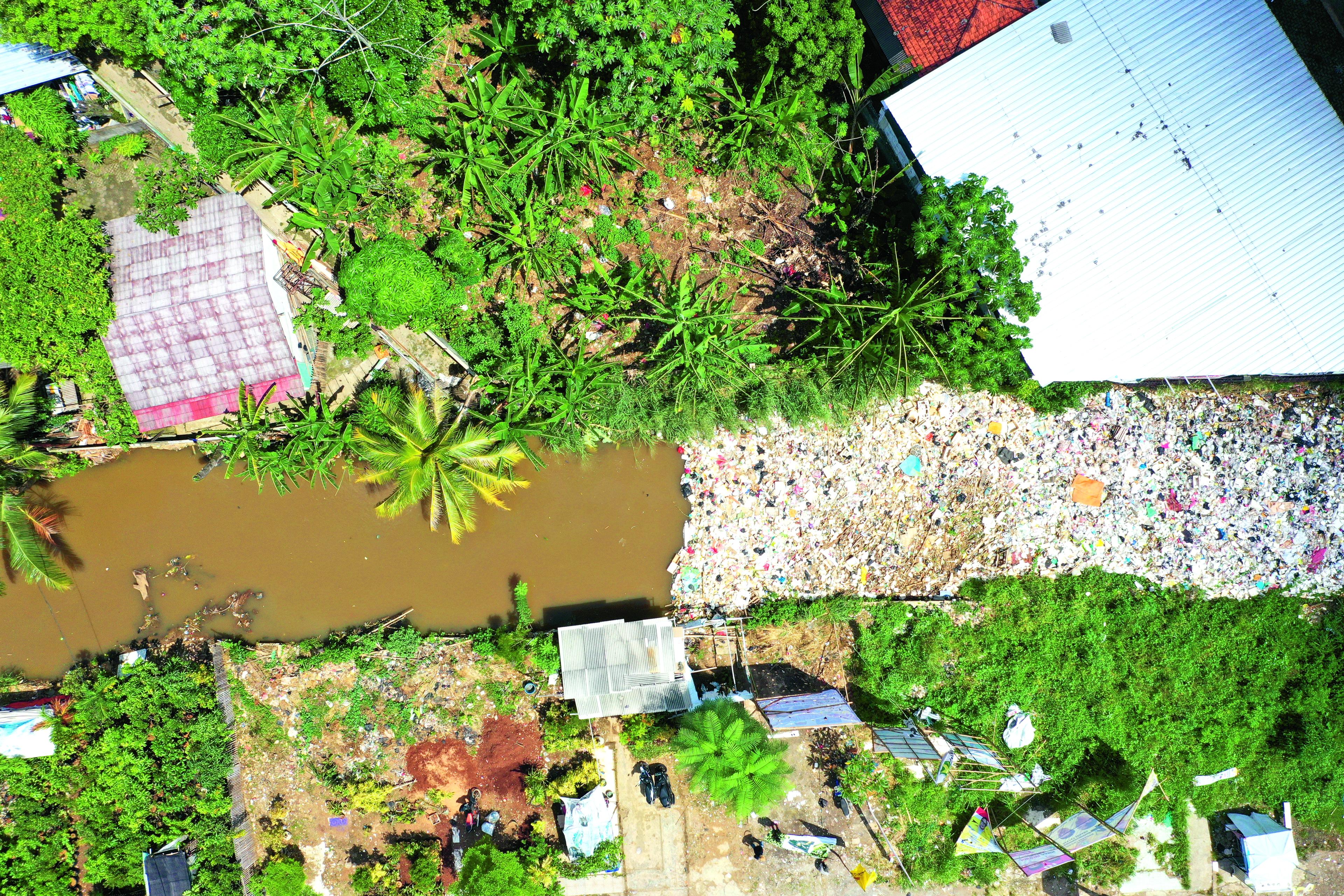 Luchtfoto van een rivier verstopt door plastic afval