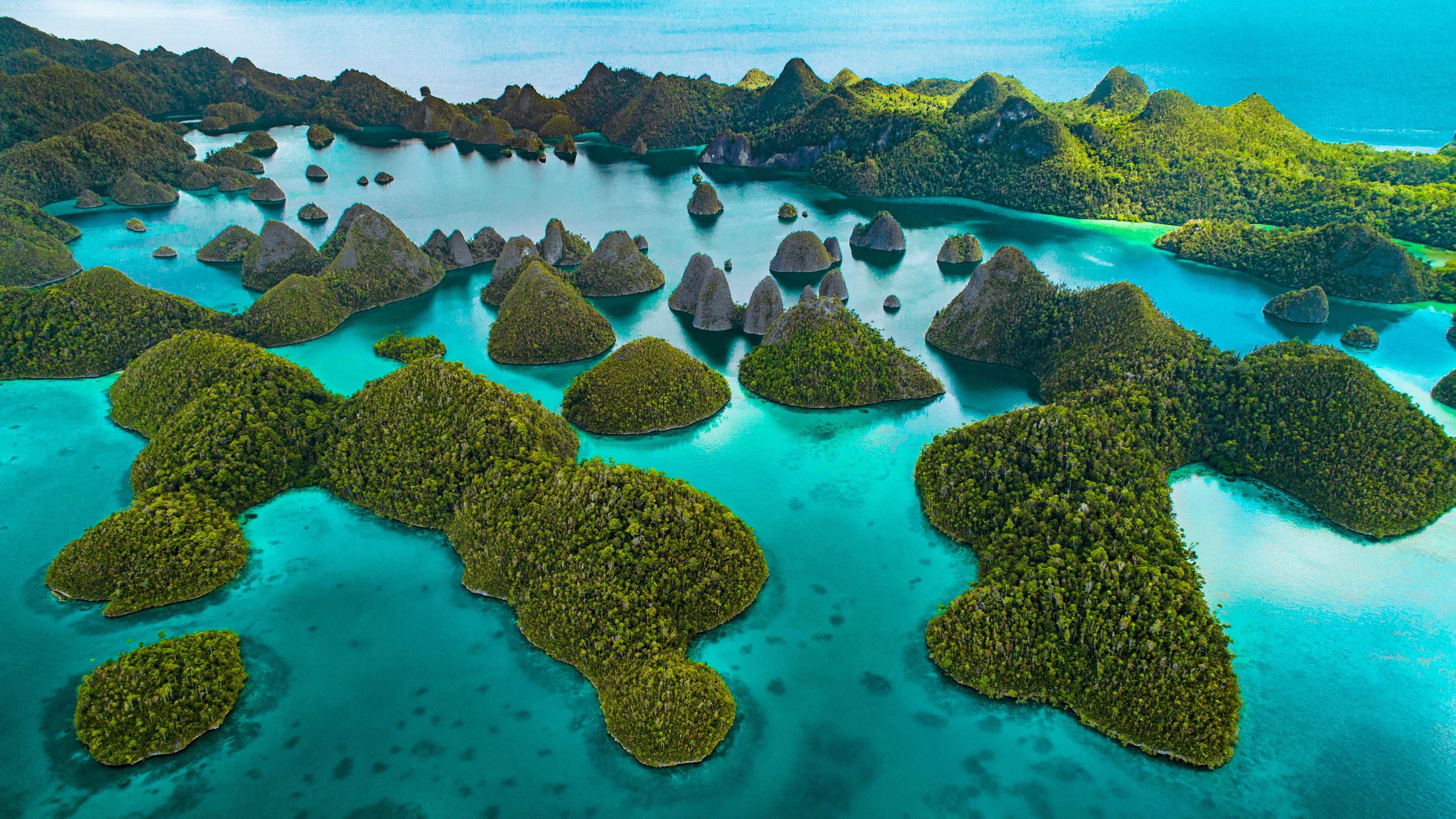 Bovenzicht van groene eilanden in blauw water, Raja Ampat, Indonesia