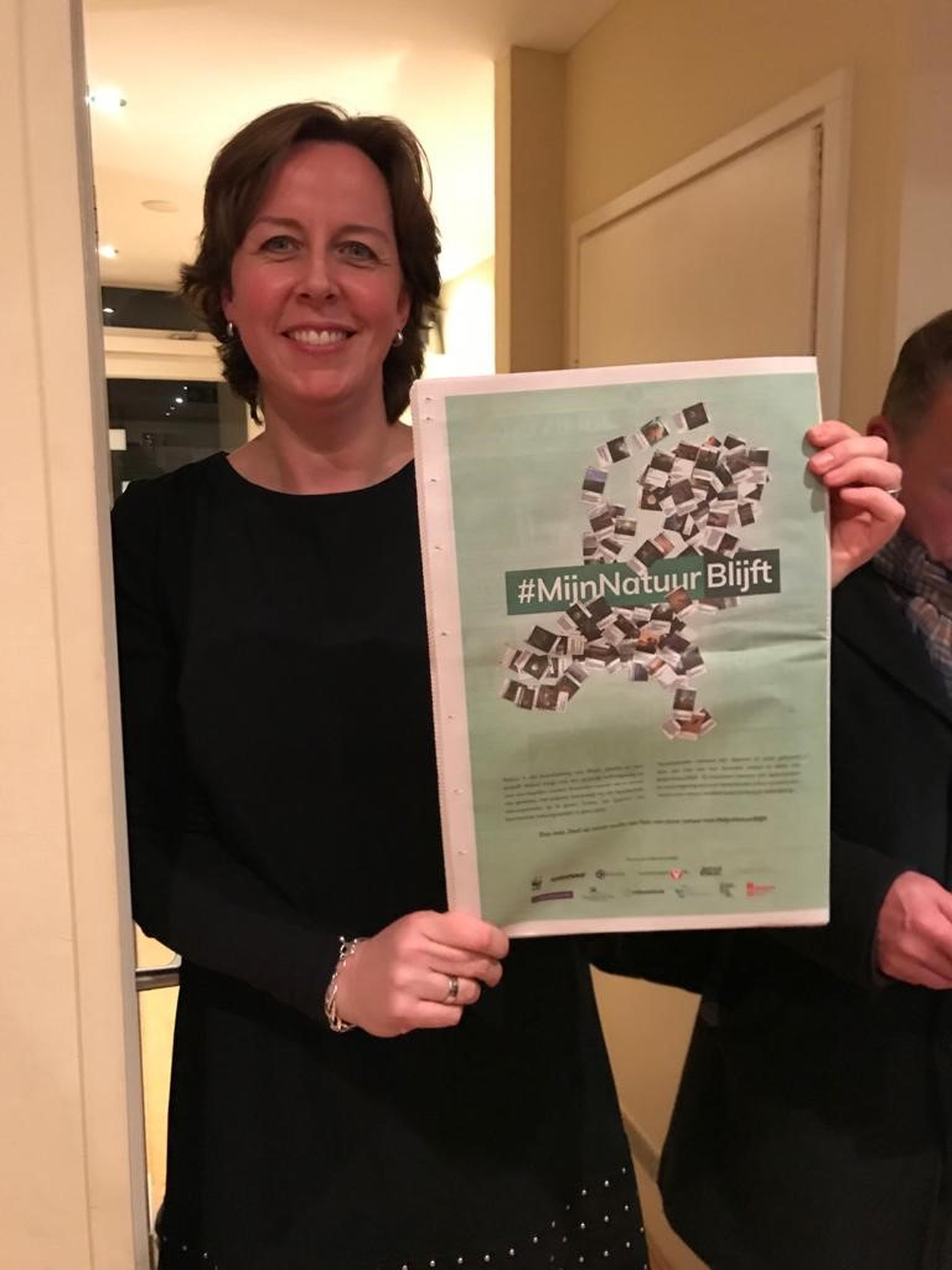 Kirsten houdt de advertentie van Mijn Natuur Blijft vast