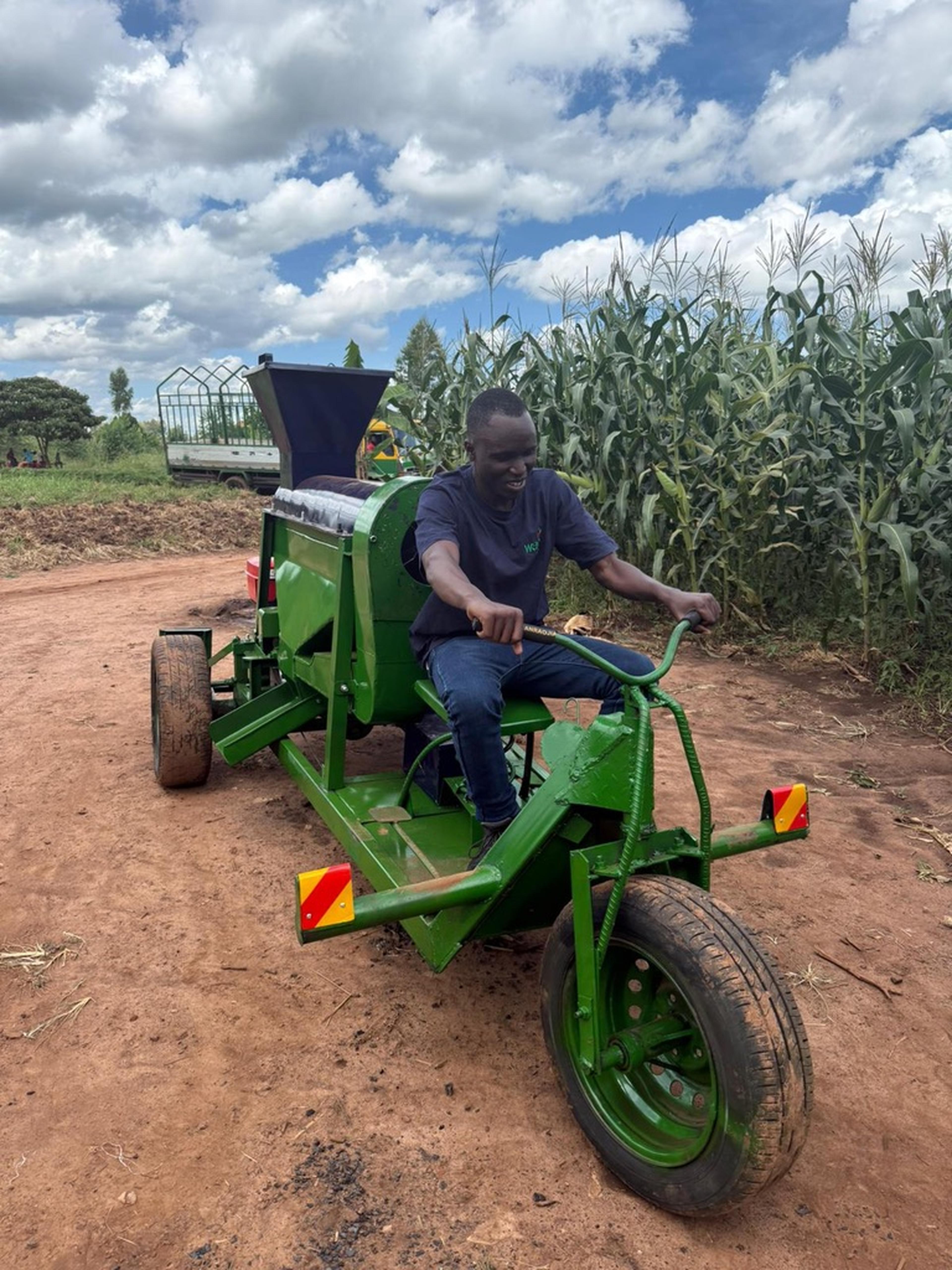 worker harvesting corn and riding a machine