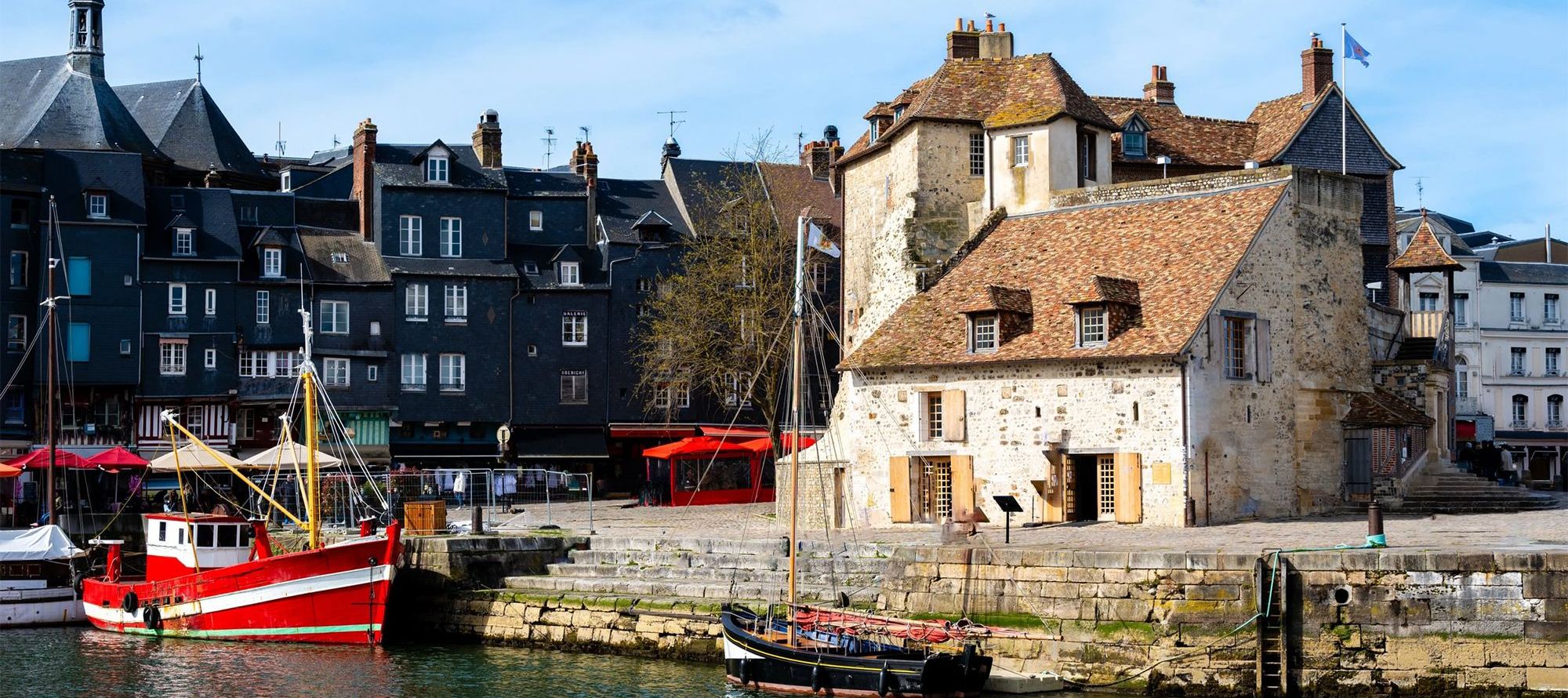 Harbor of Honfleur with the old pier, the Lieutenance house and 2 fishing boats, Normandy, France