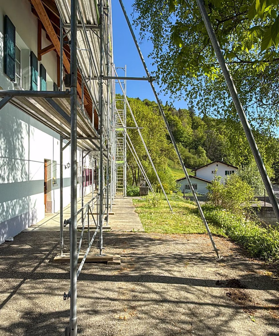 Sauber gebautes Gerüst mit Geländer und Bordbrett an einem Wohnhaus