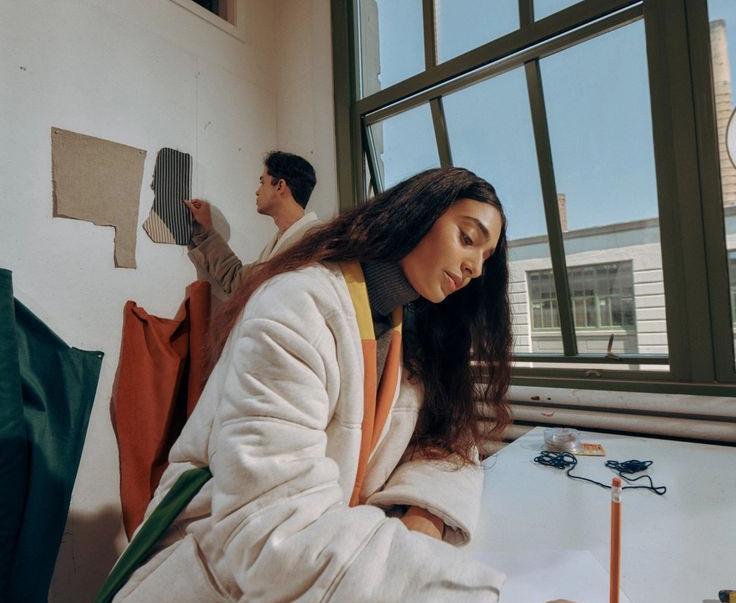 Two engineers reviewing technical drawings and test data at a workbench