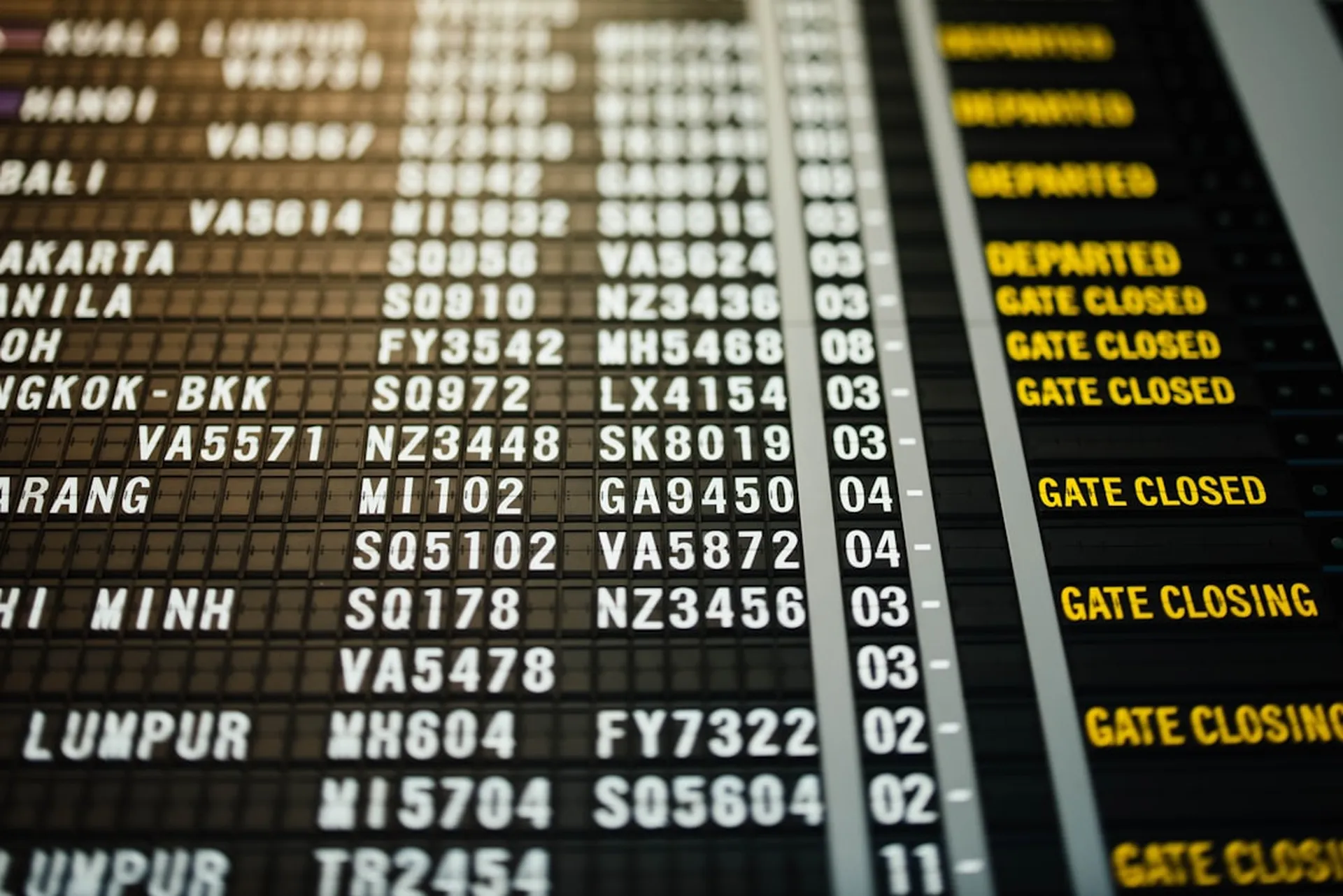 Airport split-flap departure board showing flights and times