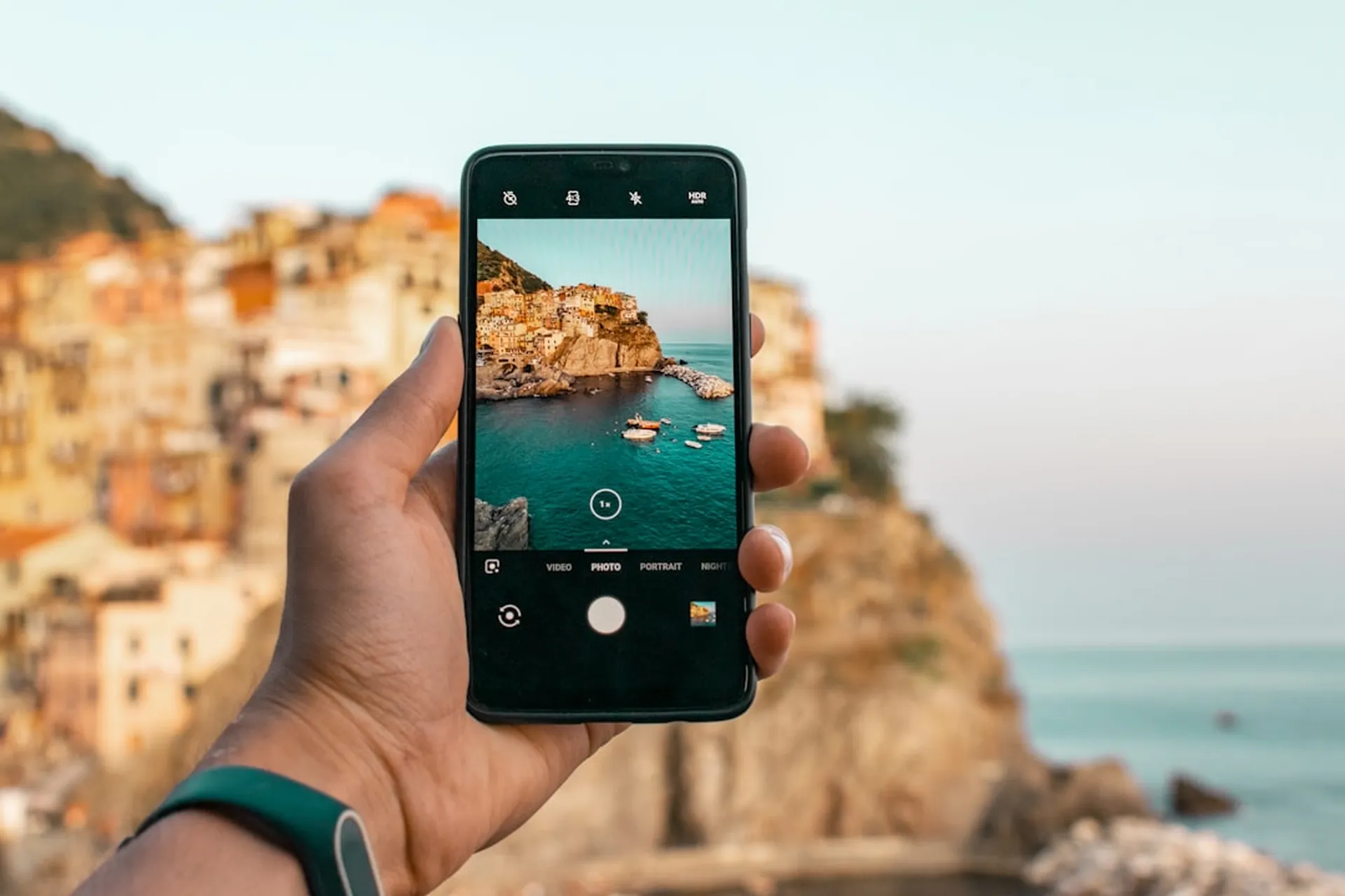 A phone photographing a coastal town