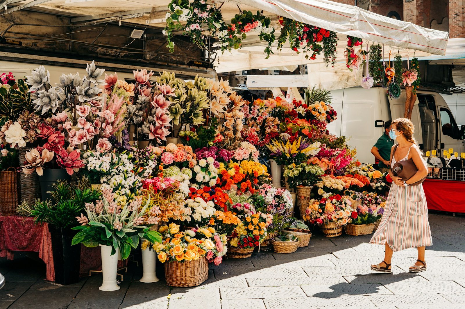 Buckets of cut flowers at a market stall.