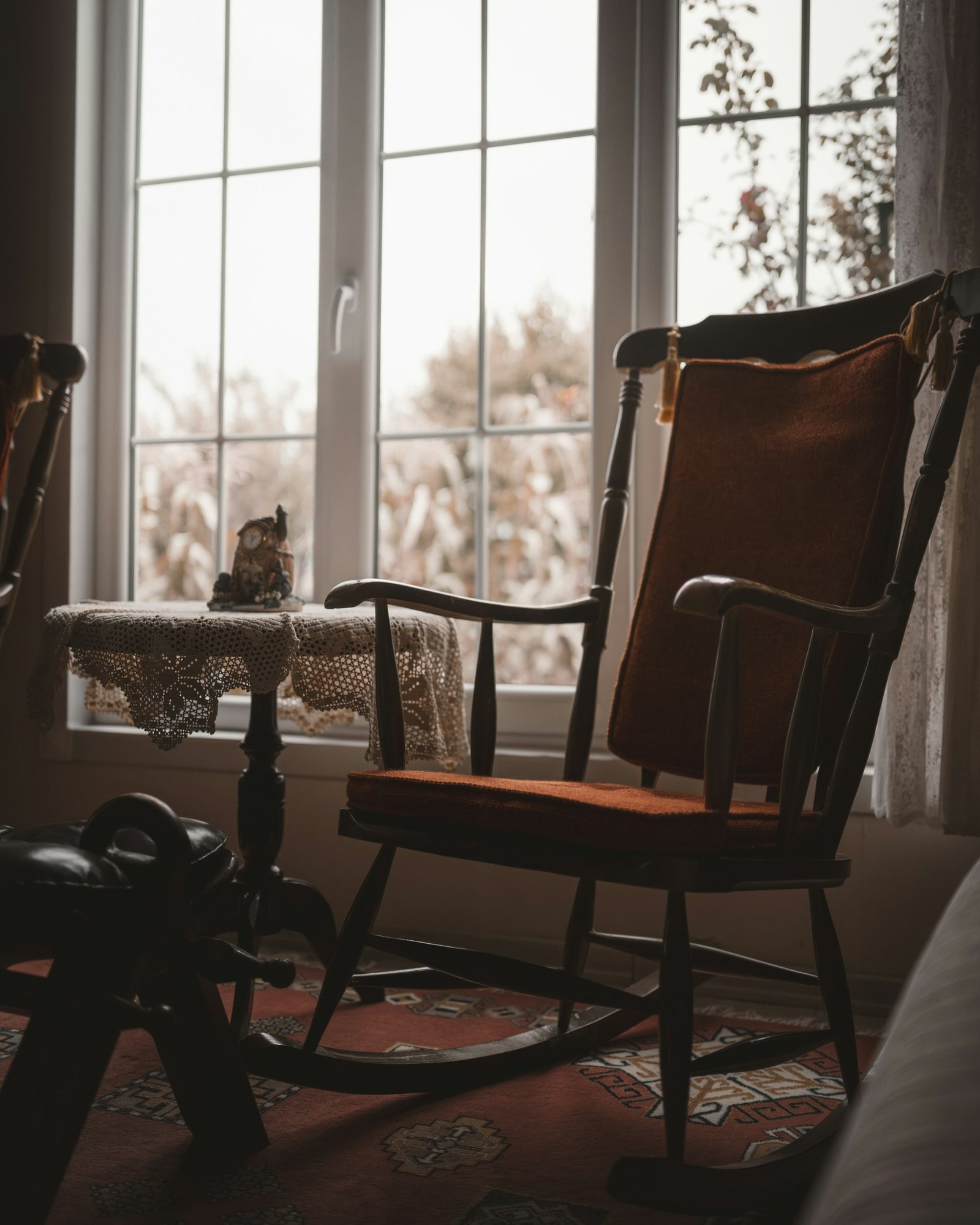 A rocking chair beside the window, looking onto the garden.