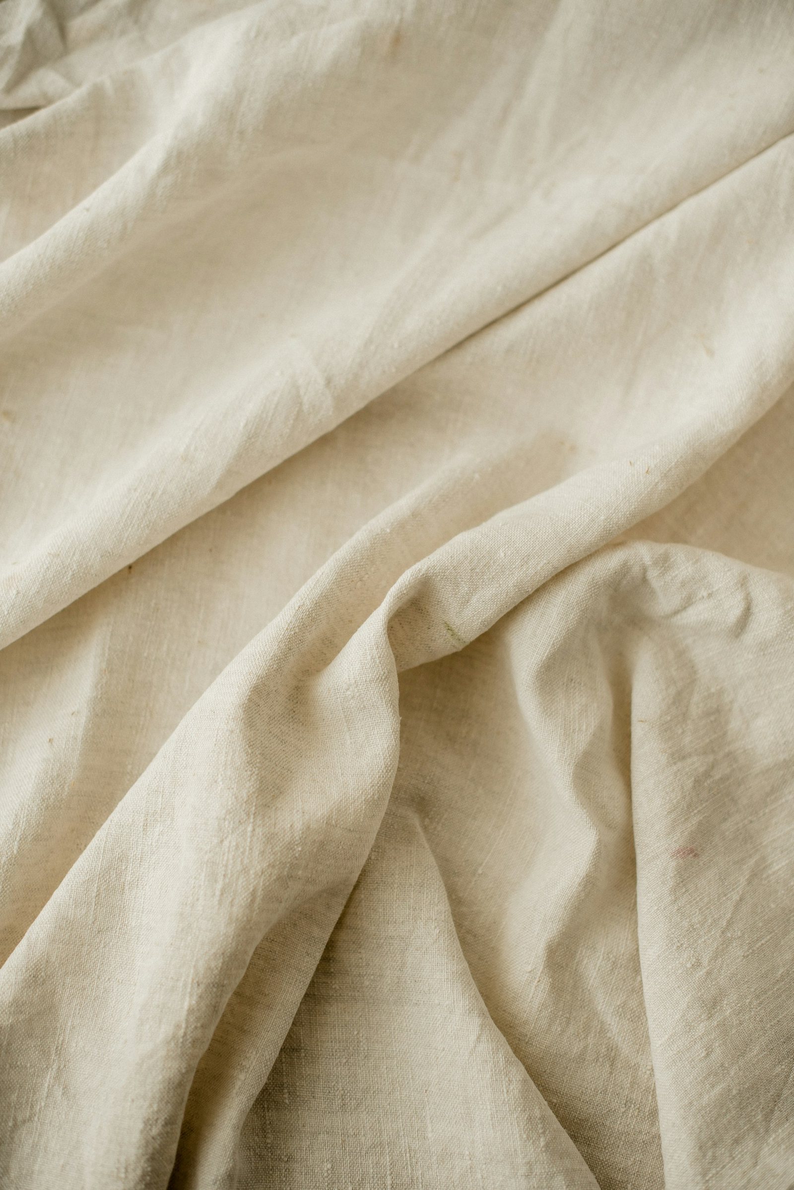 Washed cream linen in soft folds.