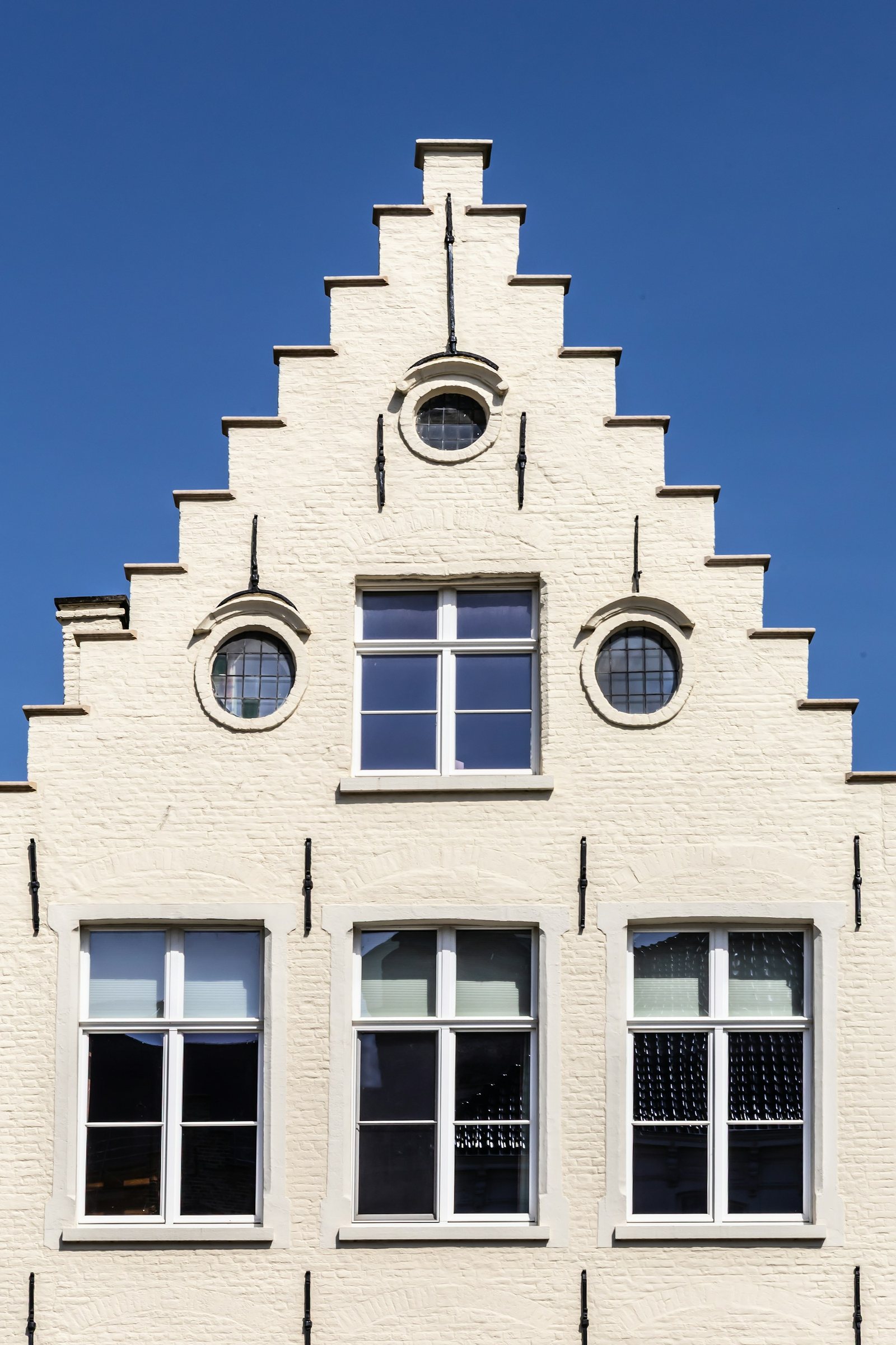 Cream stepped-gable facade of a restored Dutch seaside building.