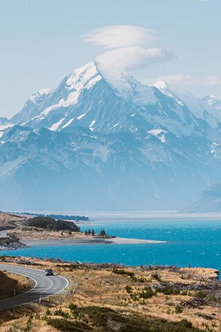 Image of Lake Pukaki in the South Island with the road in the foreground and mountains in the background