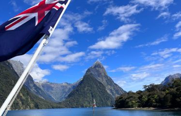 New Zealand flag waving in front of a mountain and lake