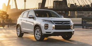 Image of a silver Mitsubishi ASX with the Auckland Harbour Bridge behind it