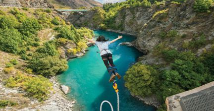 Person bungee jumping over a turquoise river