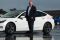 Image of a member of the GO Rentals team next to a white Tesla vehicle