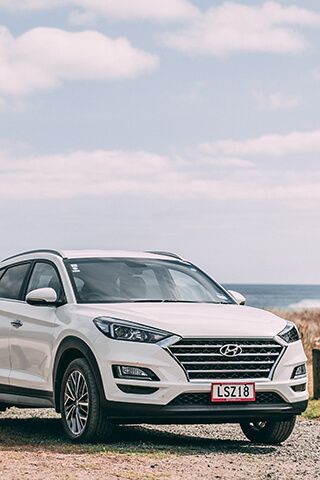 Close-up image of a new Hyundai Santa Fe rental car with pink GO Rentals plates