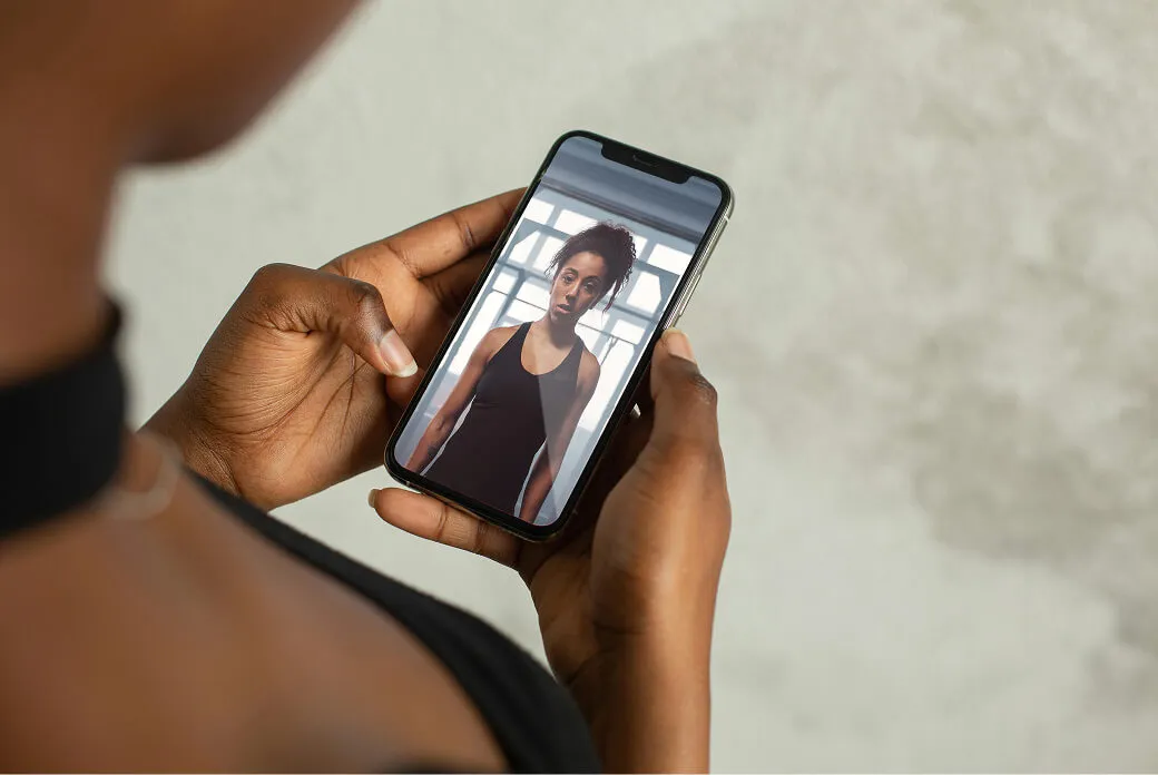 Person holding a phone showing an AI athlete avatar