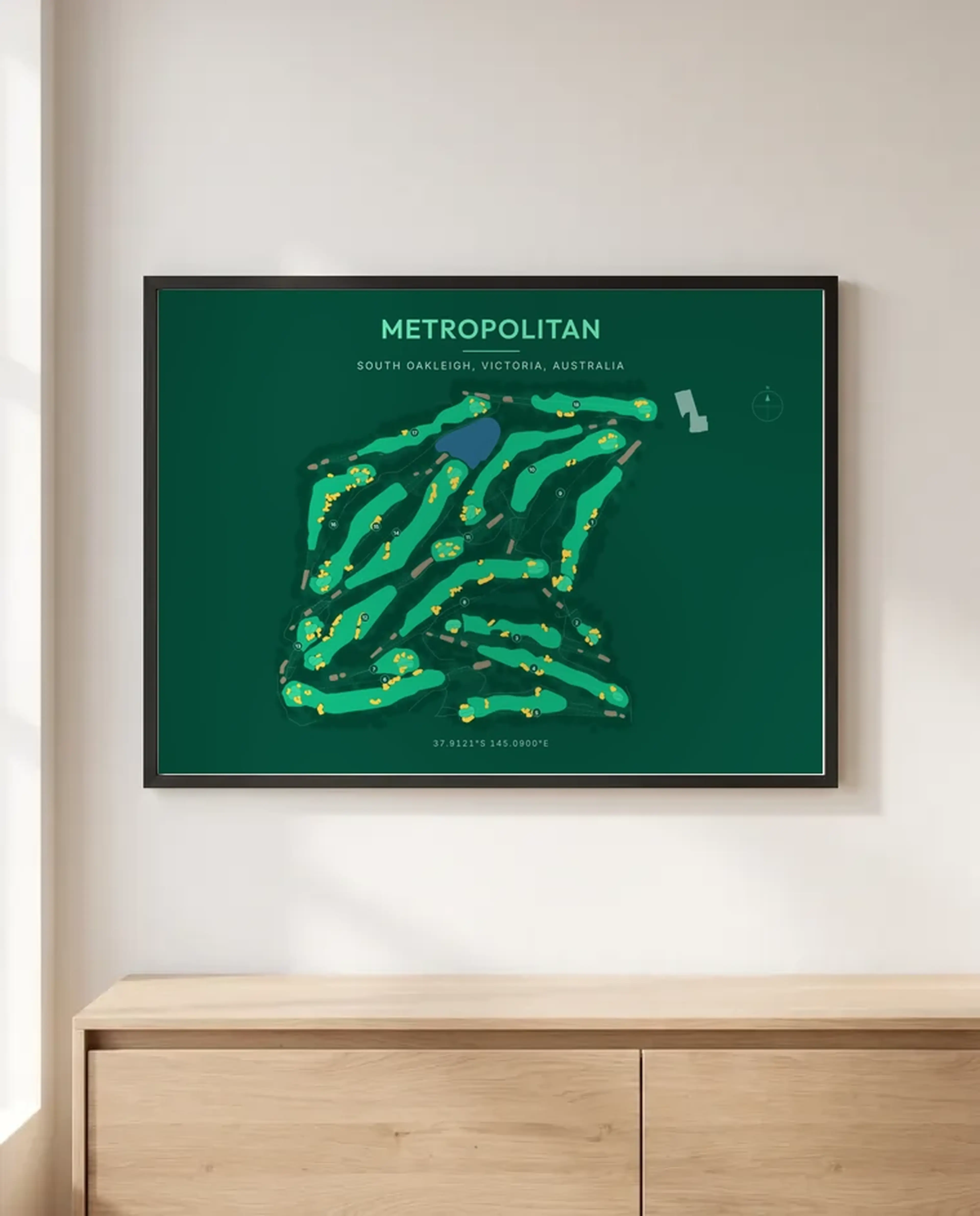 A dark green Metropolitan print in a black frame above a sideboard