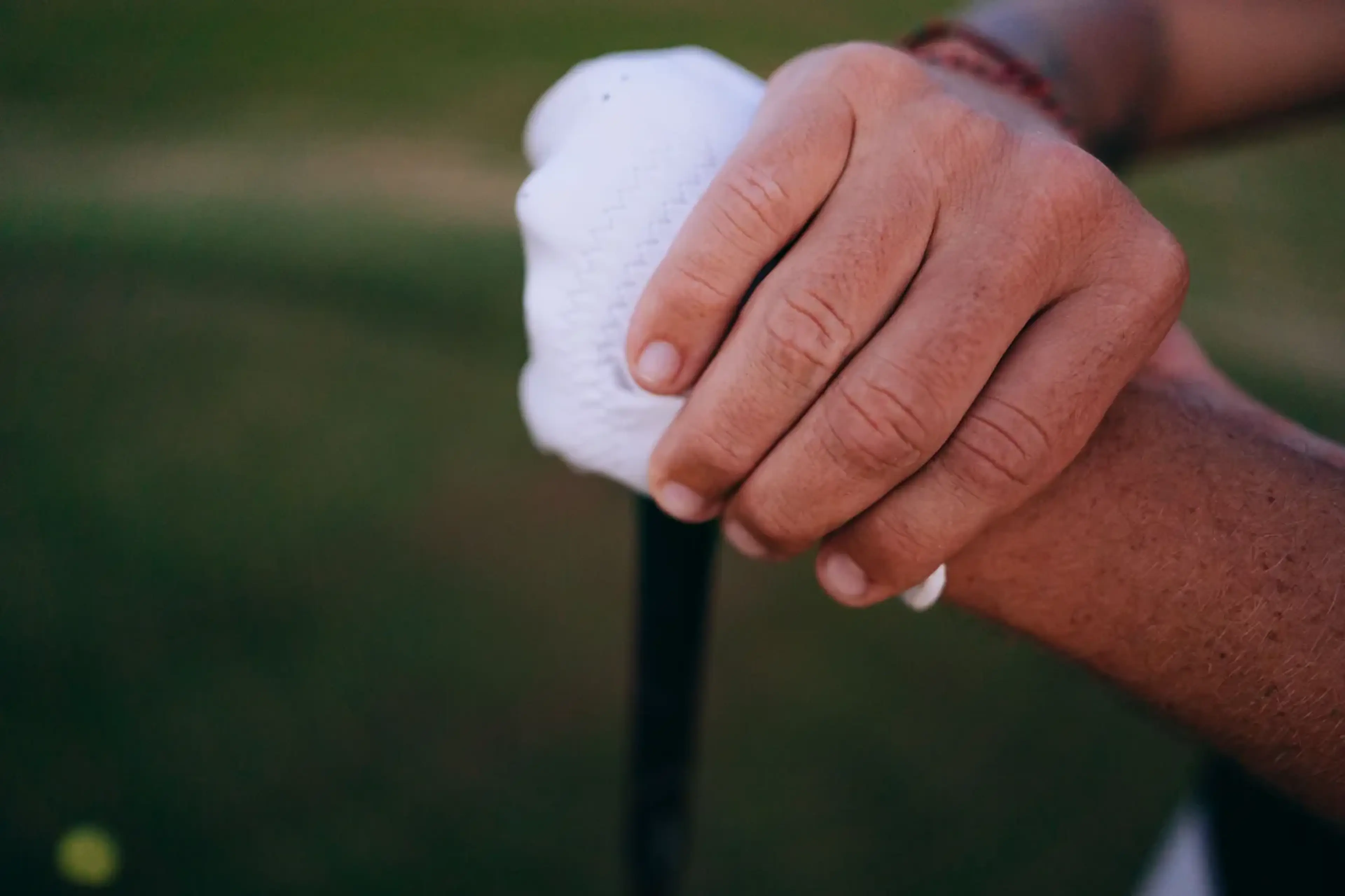 Gloved hands on a golf club grip
