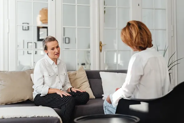 Two people in conversation across a table in a bright office