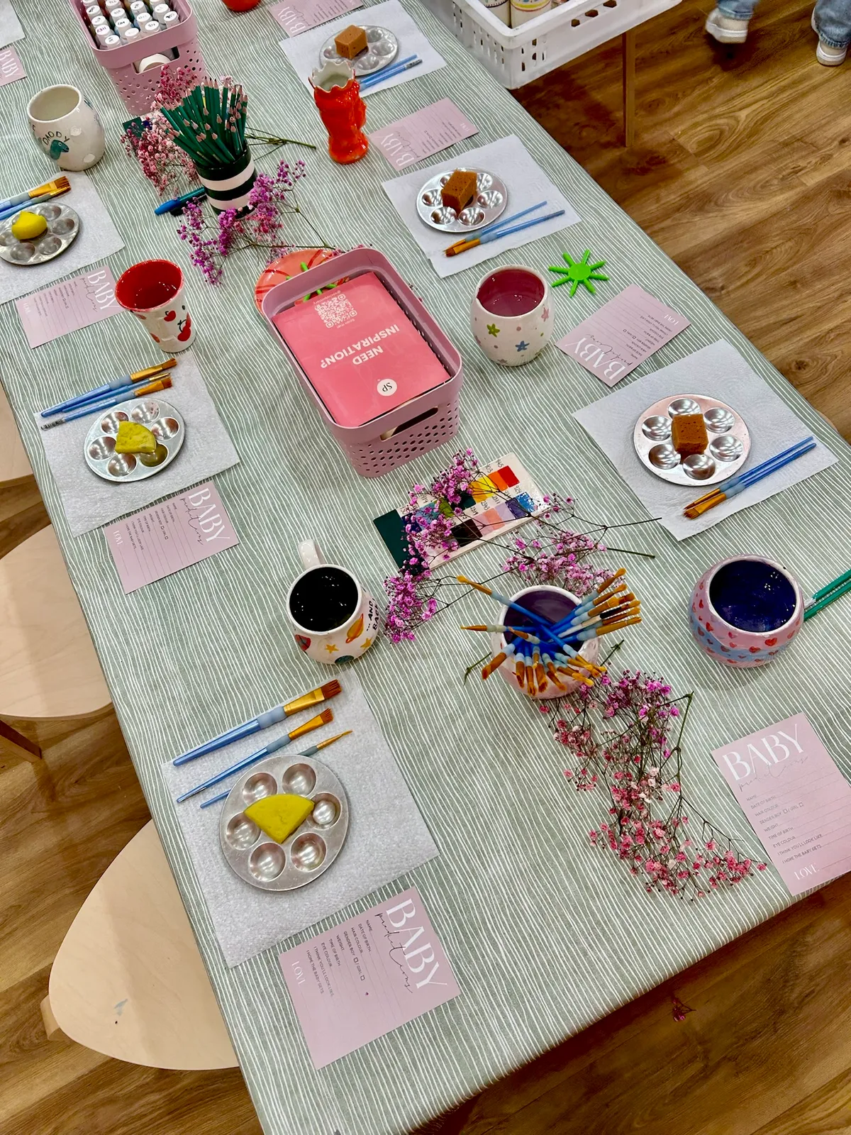 Baby shower table with prediction cards and painted keepsakes