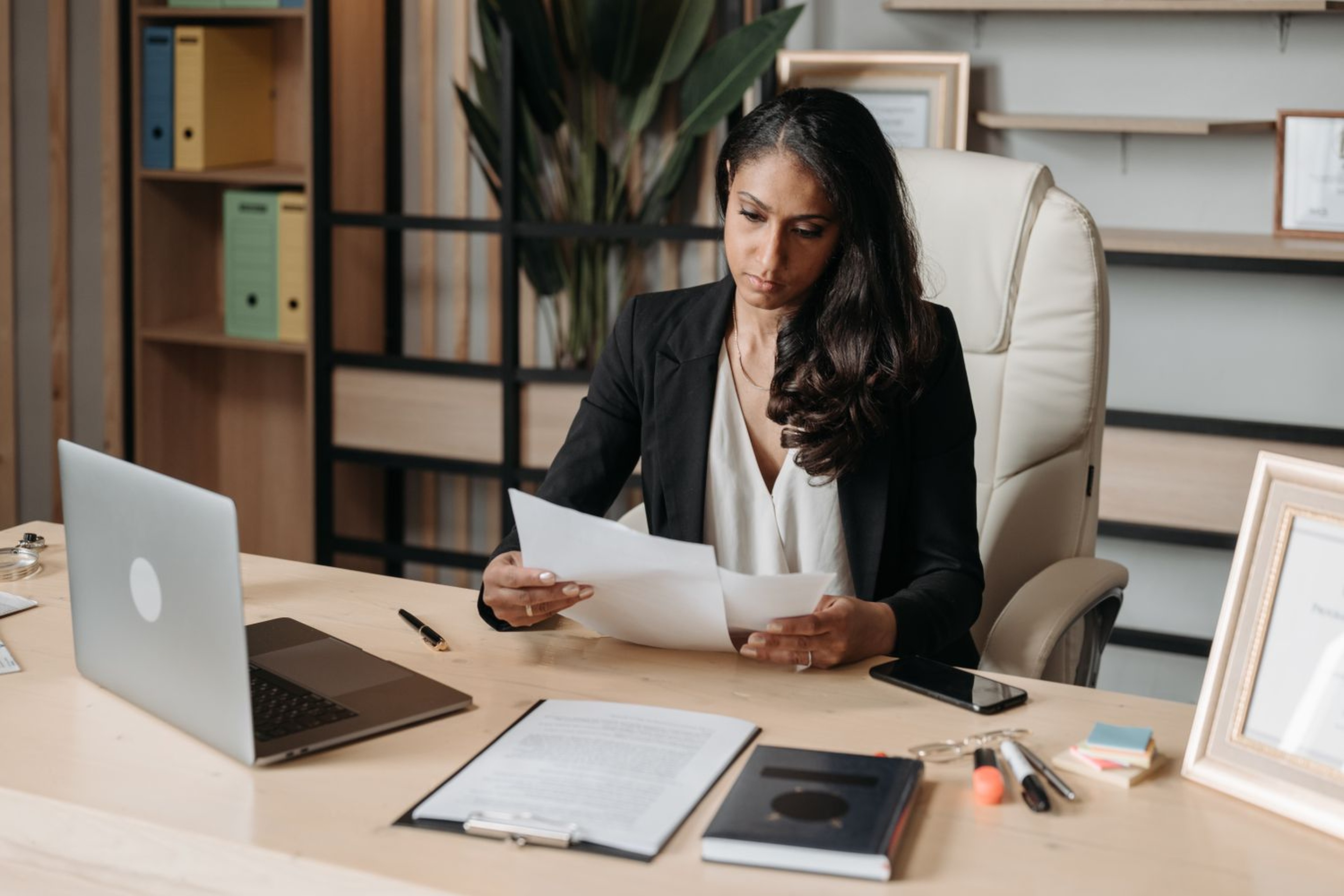 Finance manager reviewing trucking invoices and paperwork at her office desk