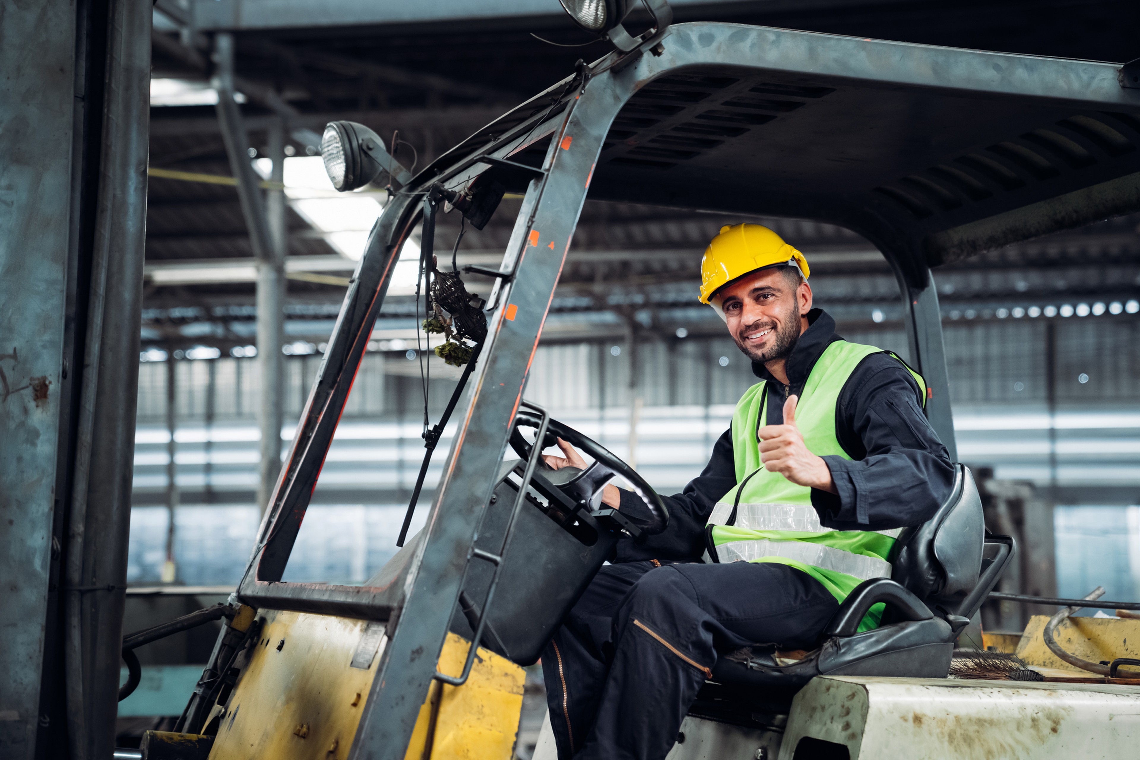 Cariste d'entrepôt souriant sur son chariot élévateur