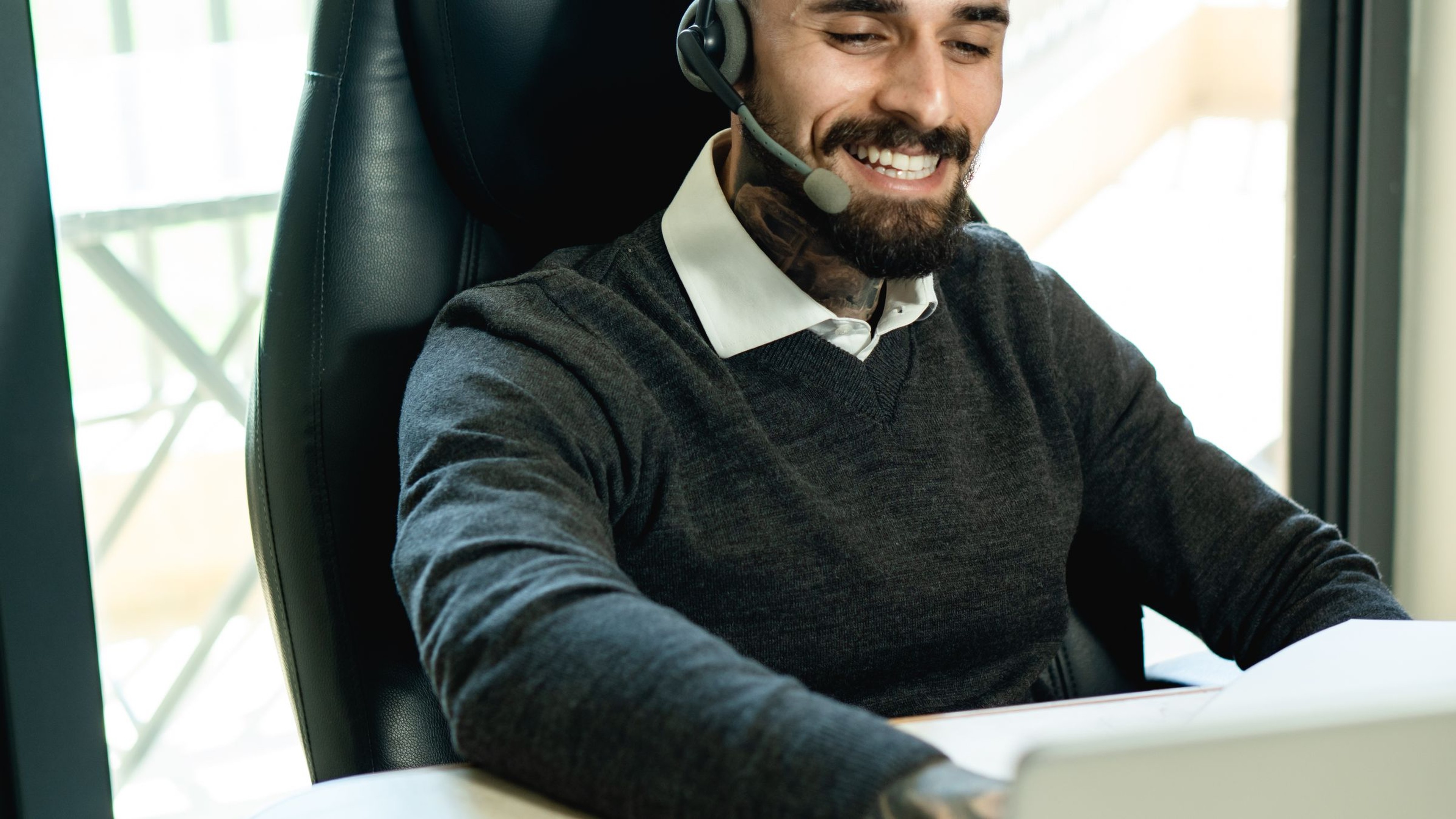 Trucking dispatcher wearing a headset while coordinating loads and driver updates at a desk in a US dispatch office