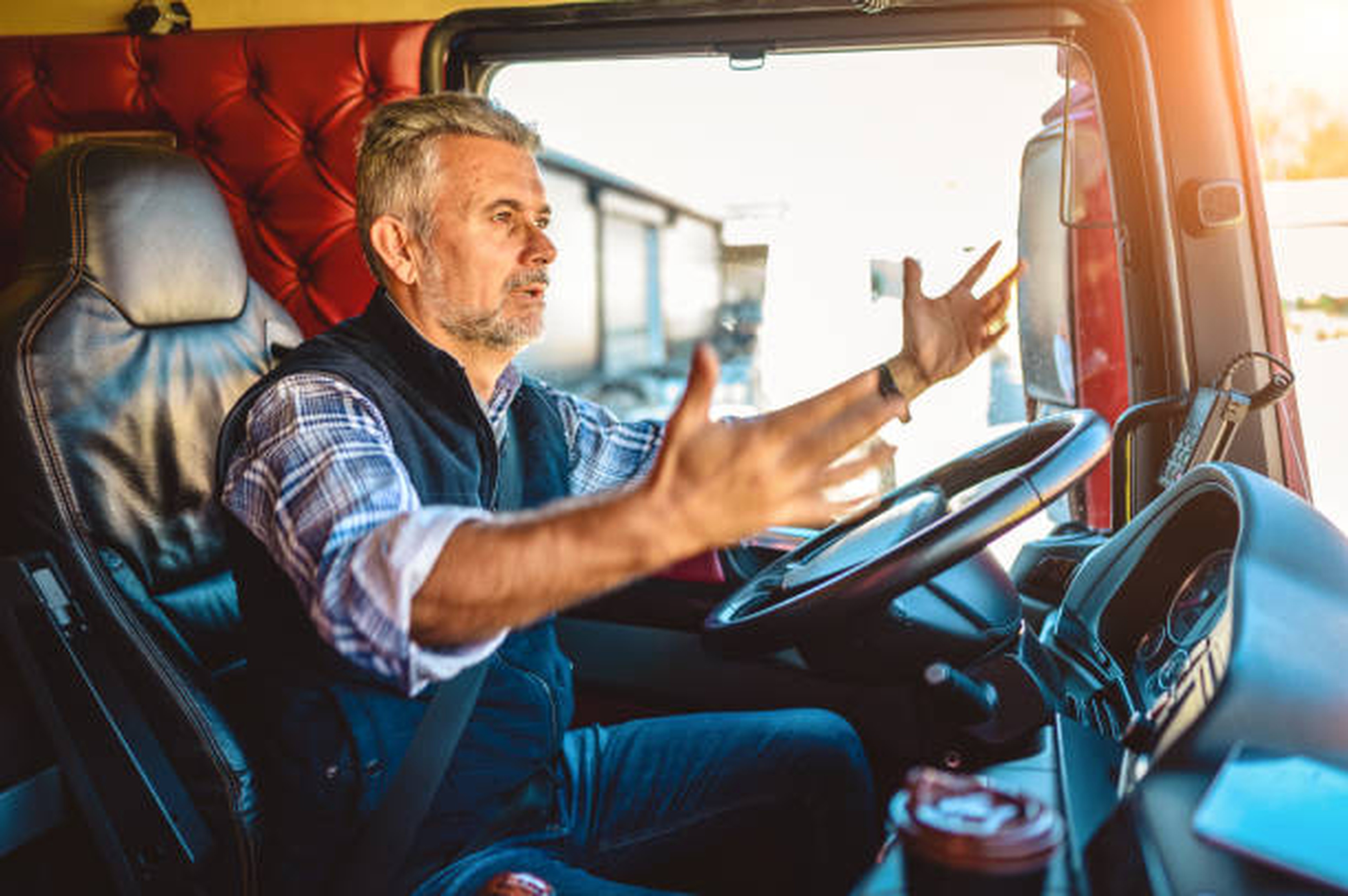 Chauffeur routier concentré gesticulant dans sa cabine, illustrant les tensions liées à un litige transport ou un problème de facturation.