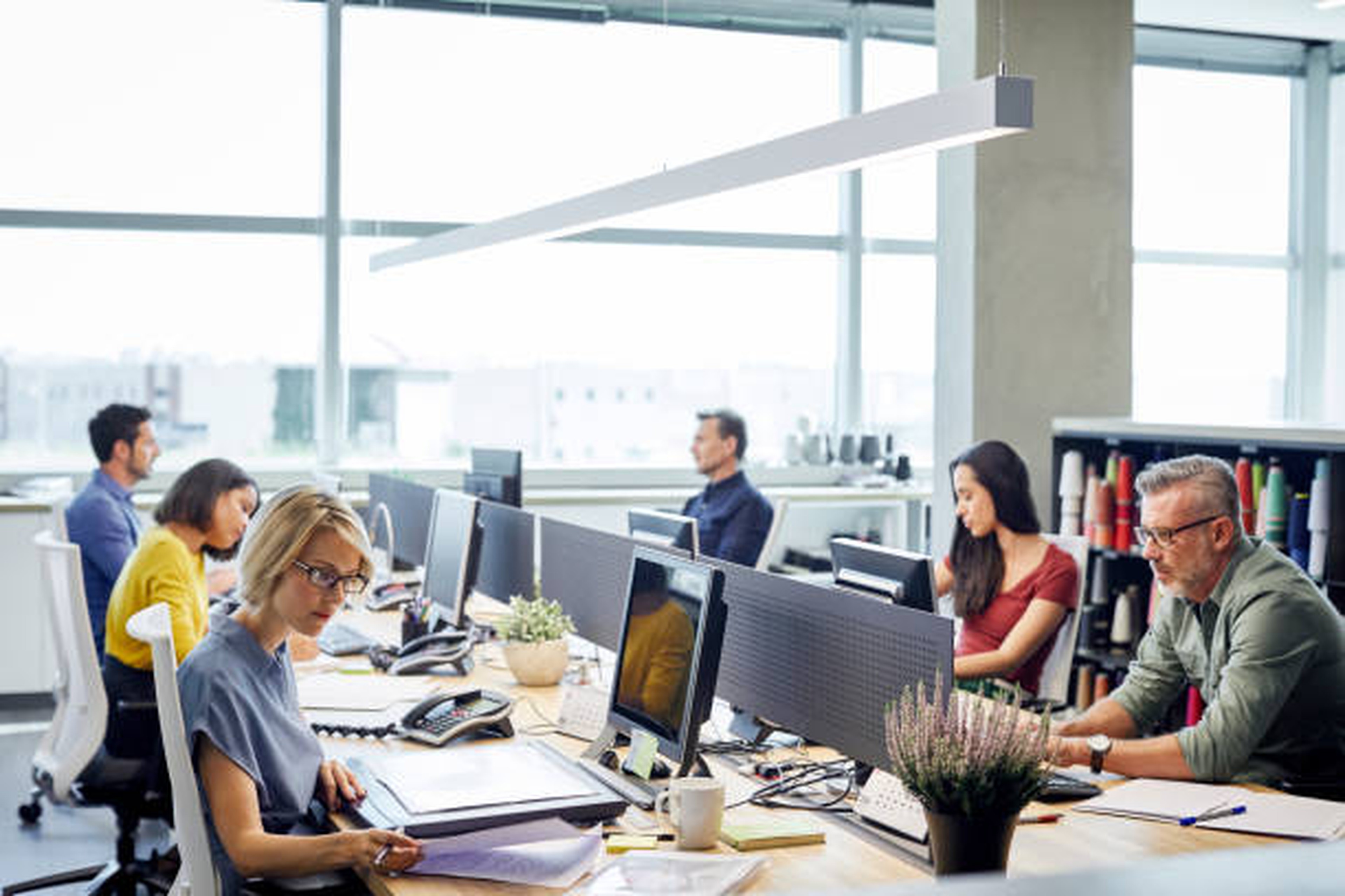 Employés travaillant dans un bureau open space sur la gestion des factures transport"