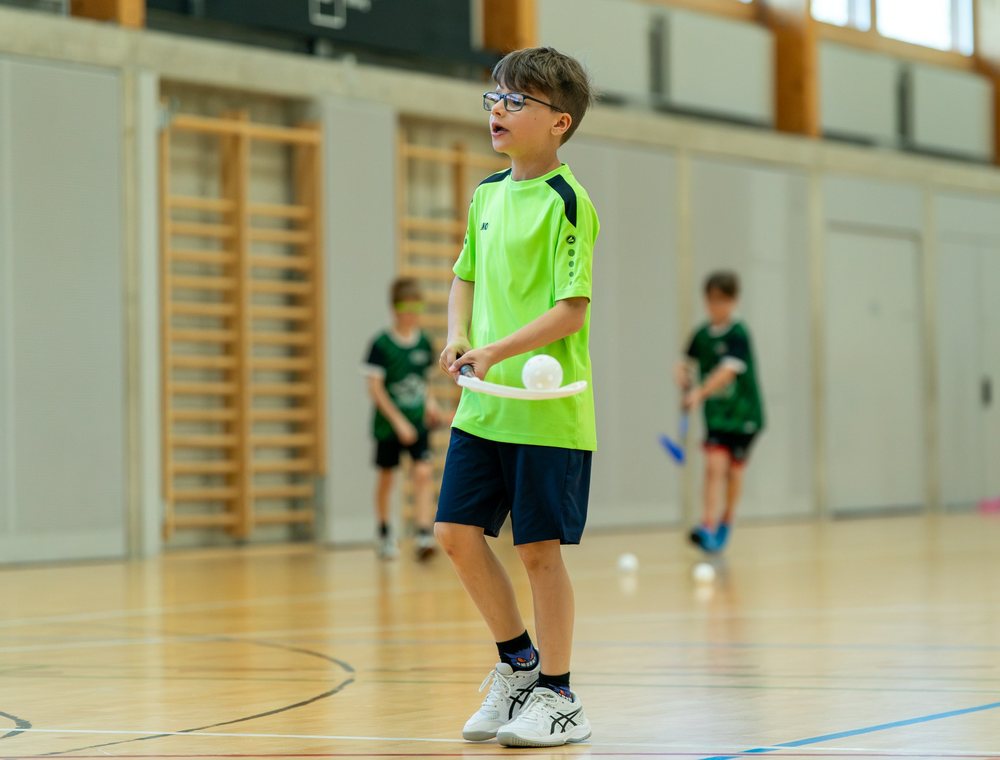 Kind beim Werfen eines Balls in der Sporthalle