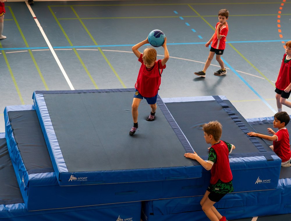 Kinder beim Basketballspiel mit Trampolin