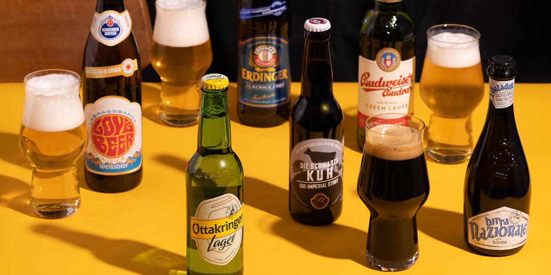 Biersorten in Flaschen und Gläsern auf gelbem Grund