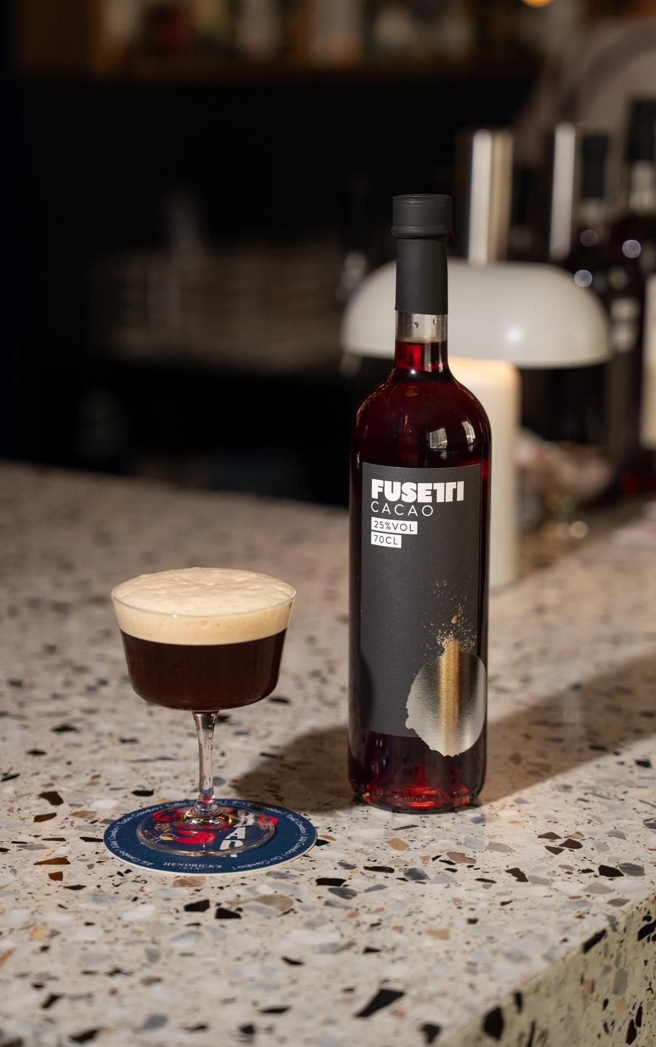 Espresso Martini neben einer Flasche Fuseiti Cacao auf dem Tresen