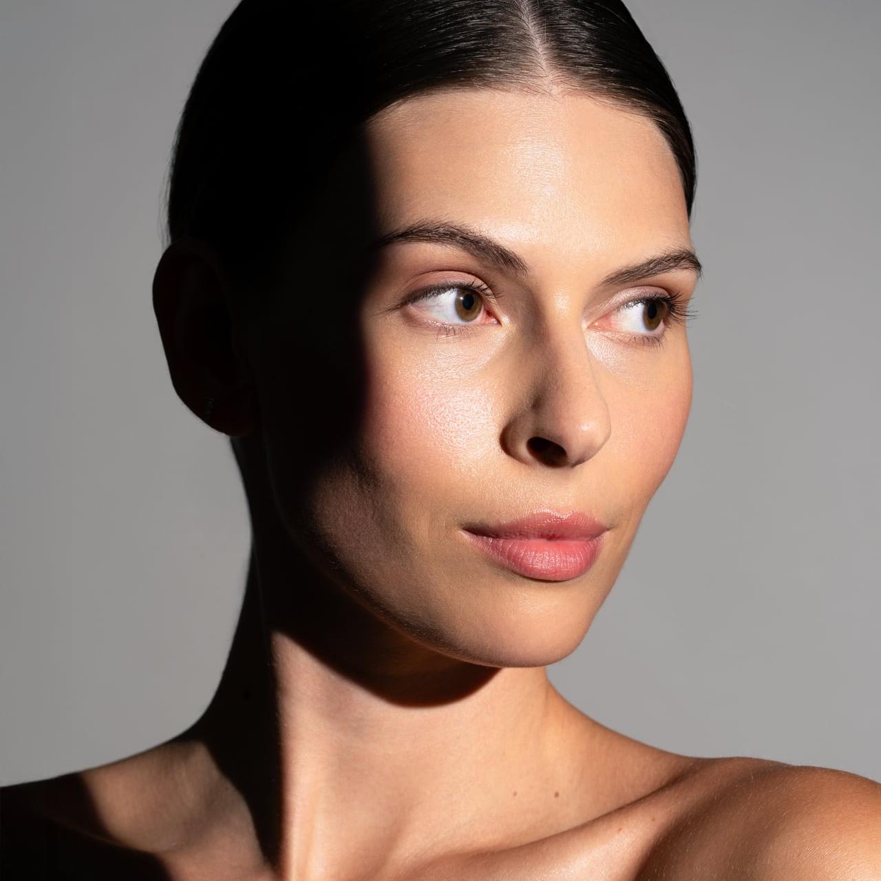 Portrait einer Frau mit Schlagschatten auf hellem Grund