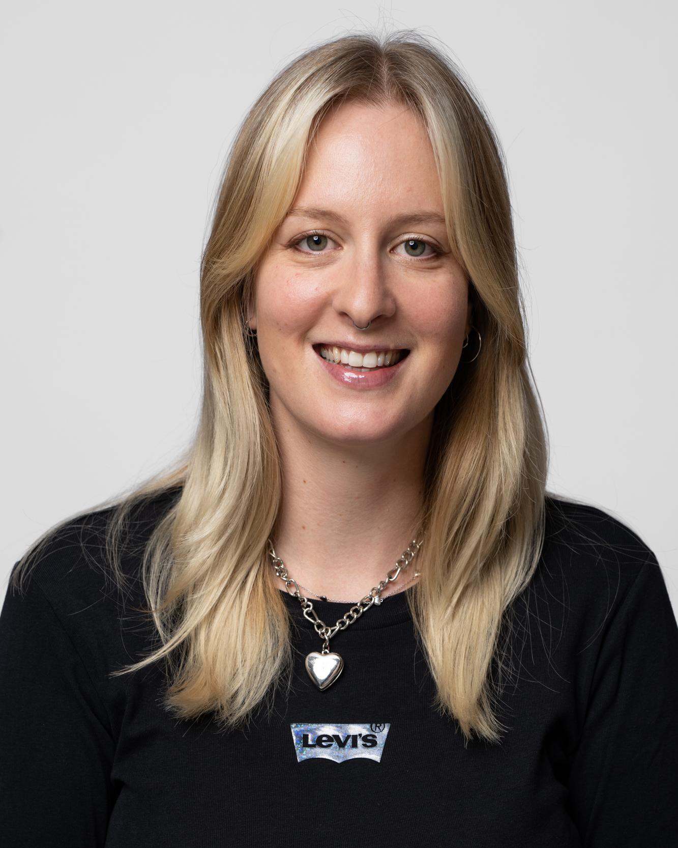 Elisa Kroiss im schwarzen Blazer mit Herzkette