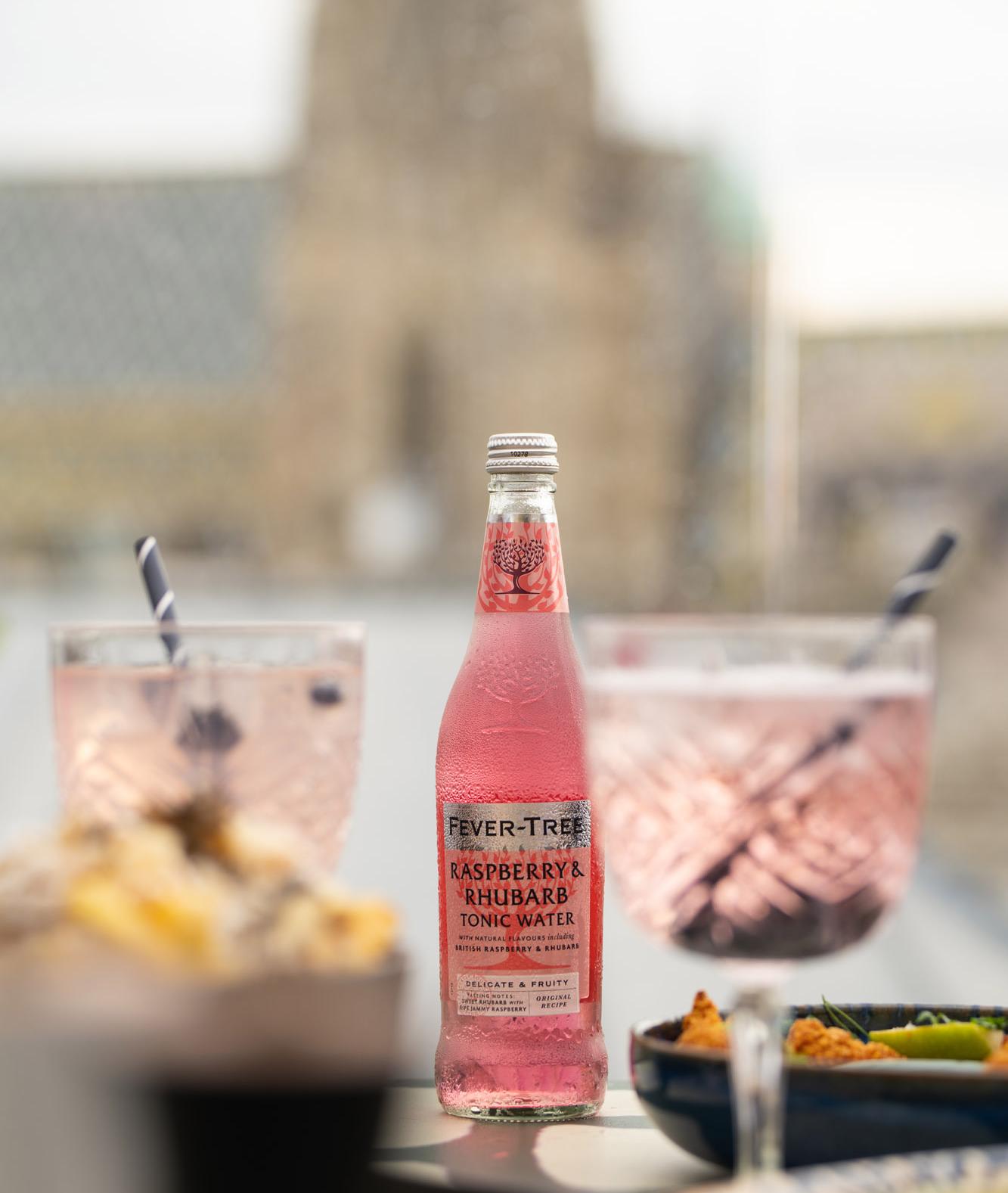Fever-Tree-Flasche neben zwei rosa Cocktails