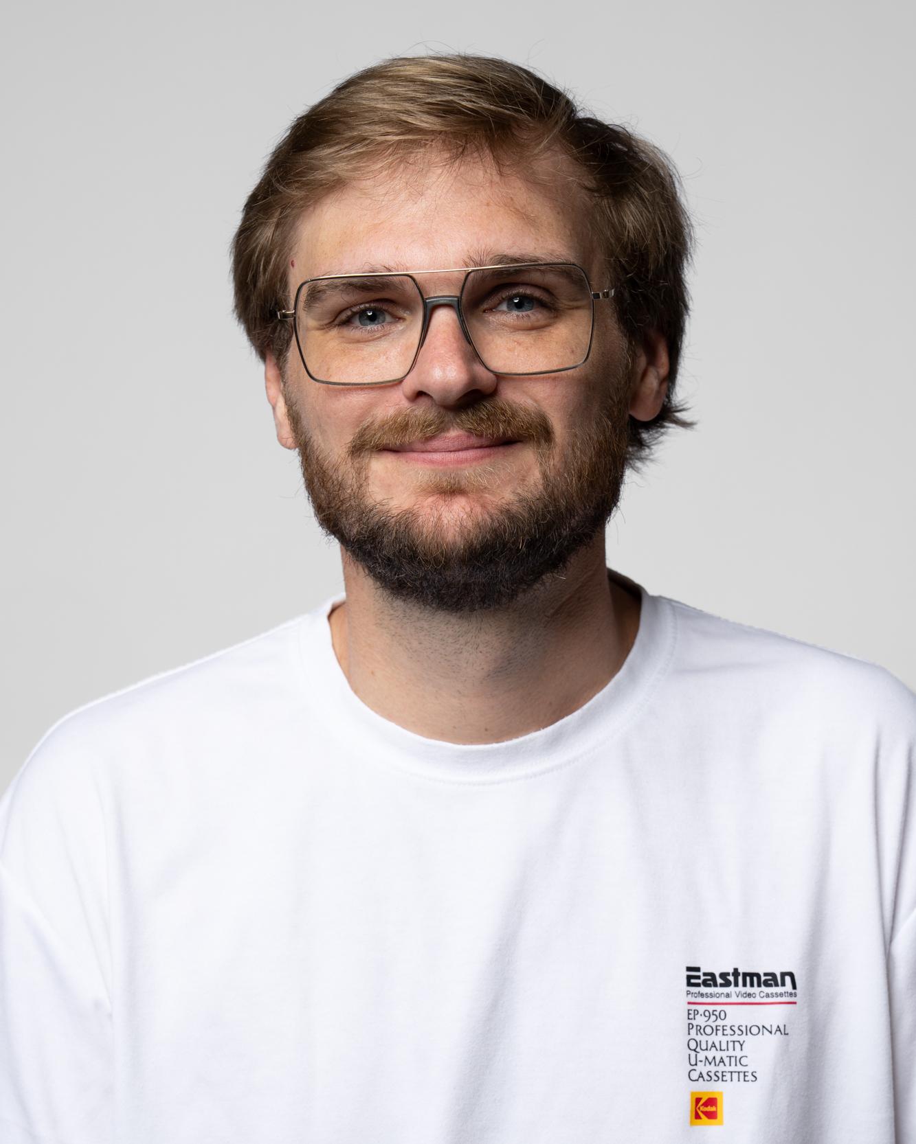 Teammitglied mit Bart im weißen T-Shirt