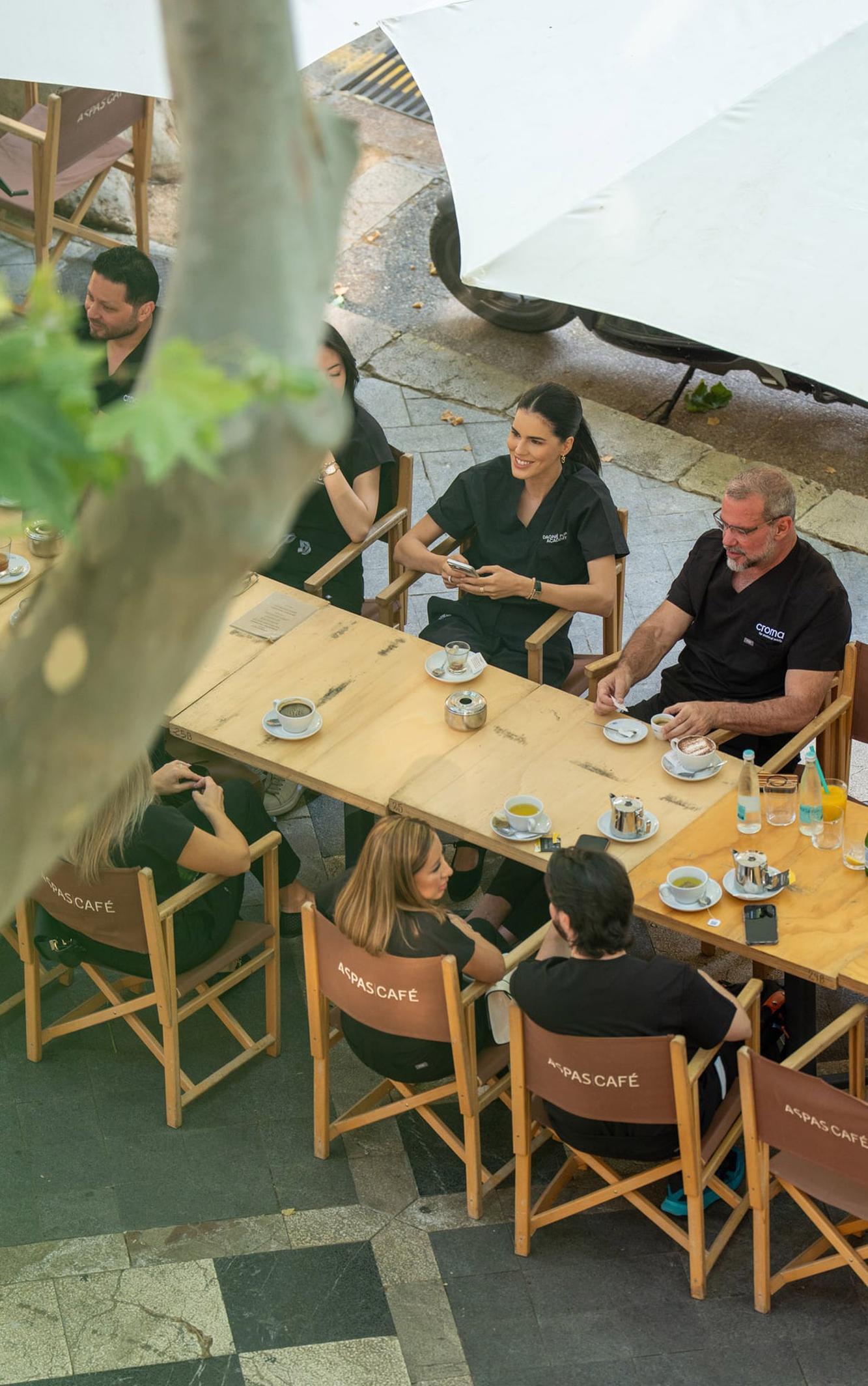 Blick von oben auf eine Kaffeetafel im Freien mit mehreren Gästen
